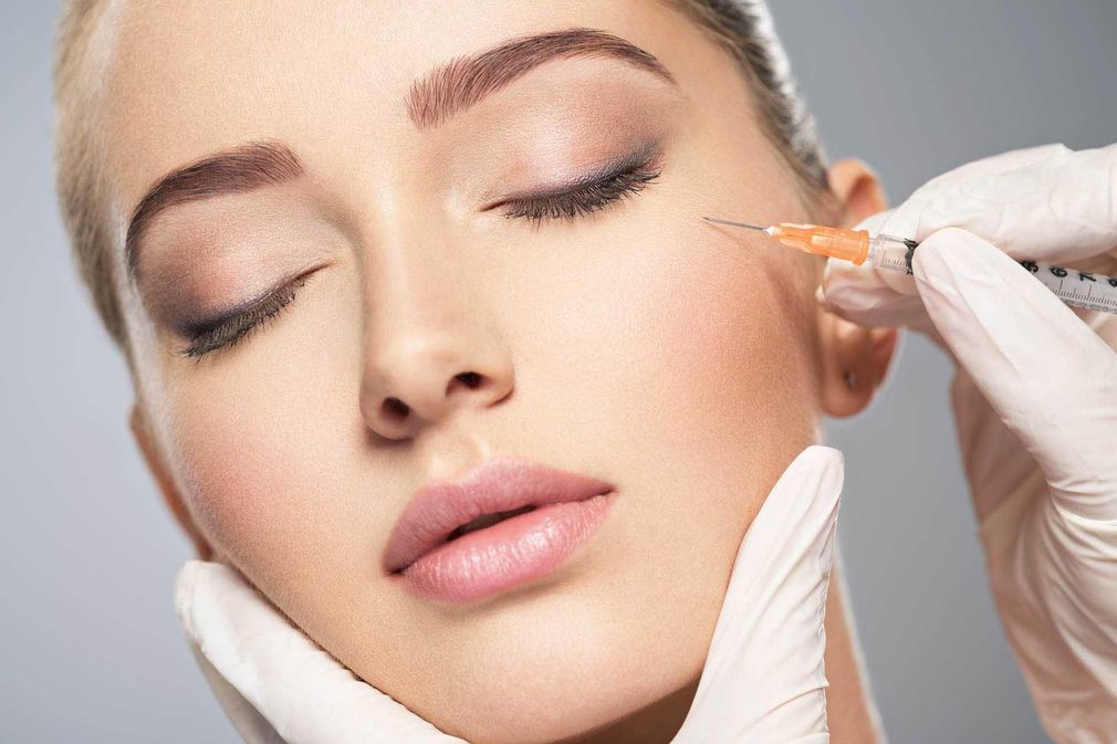Close-up of a person receiving a cosmetic facial injection near the cheek
