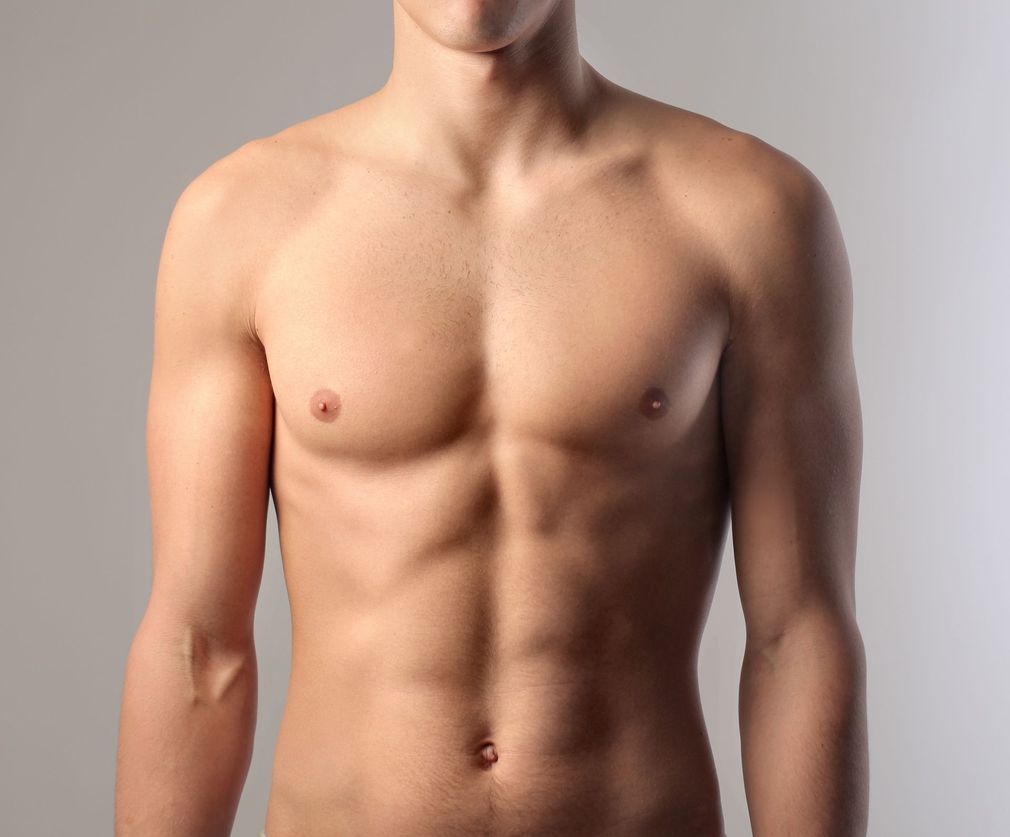 Torso of a shirtless person against a plain light background