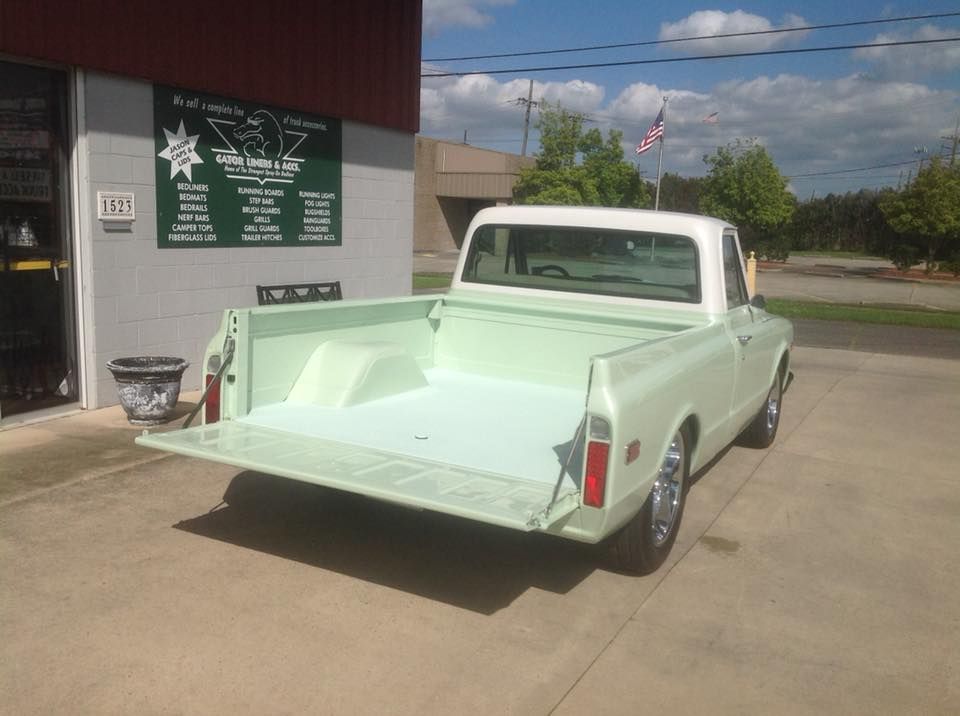 A white truck is parked in front of a building