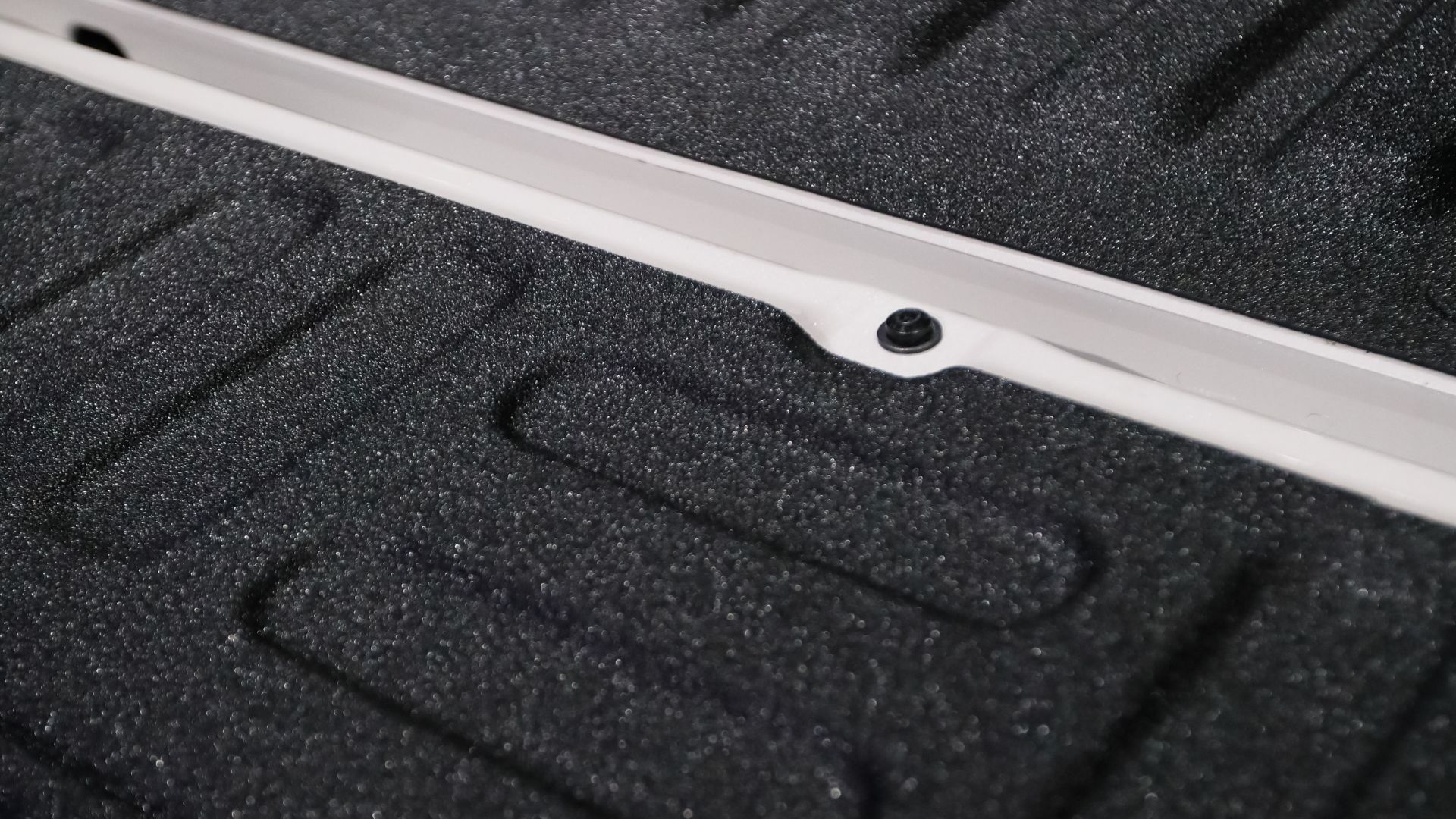 A close up of a white railing on a black surface.