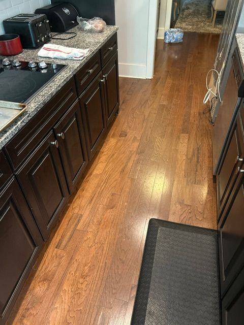 Kitchen with dark cabinets, hardwood floors, and a stove.