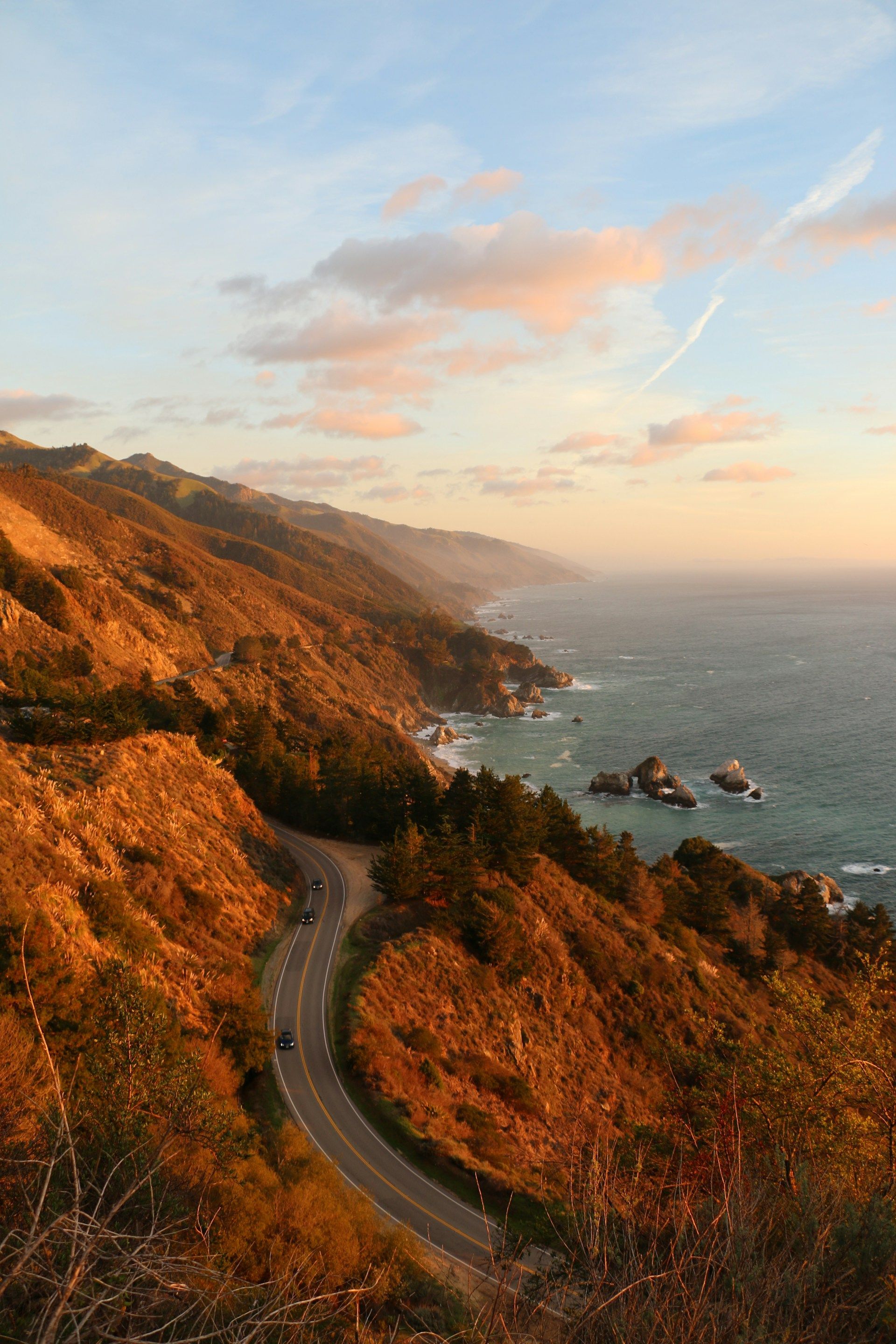 An aerial view of a curvy road leading to the ocean.