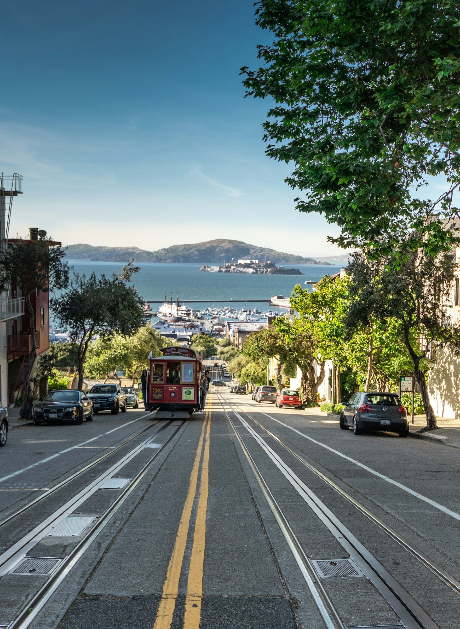 A trolley is going down a hill in a city.
