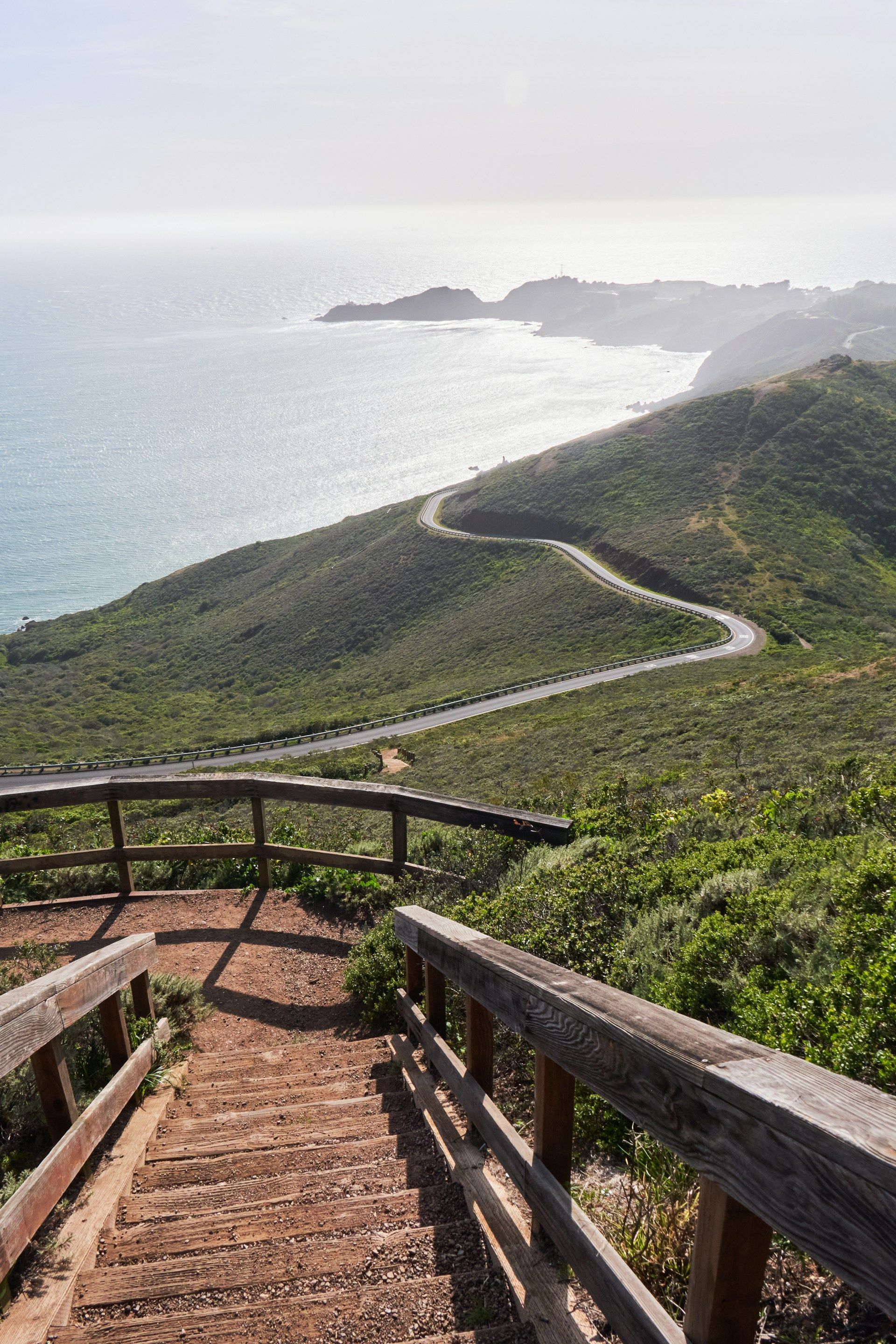 A wooden staircase leading up to a cliff overlooking the ocean.
