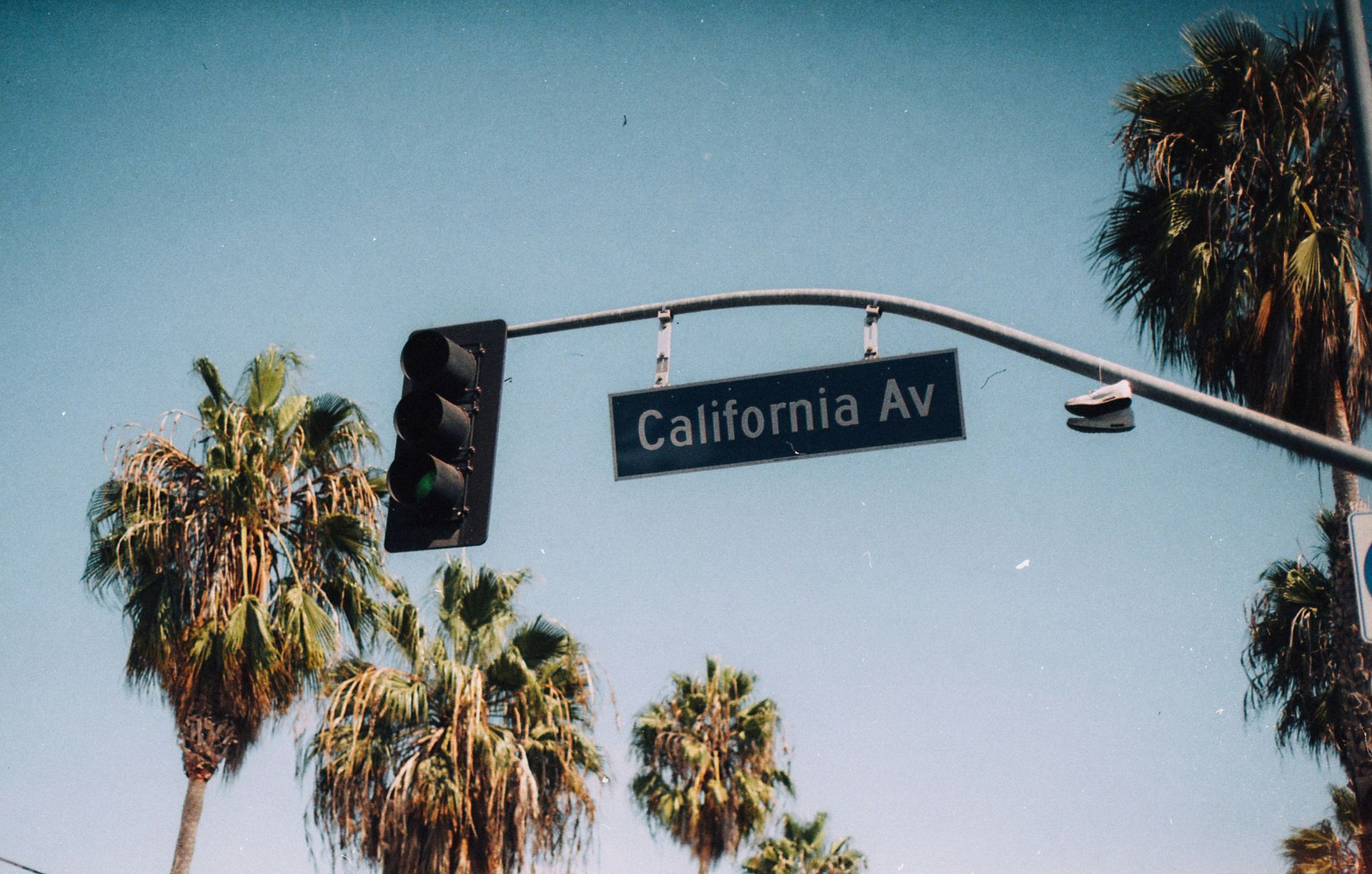A street sign for california av hanging from a traffic light