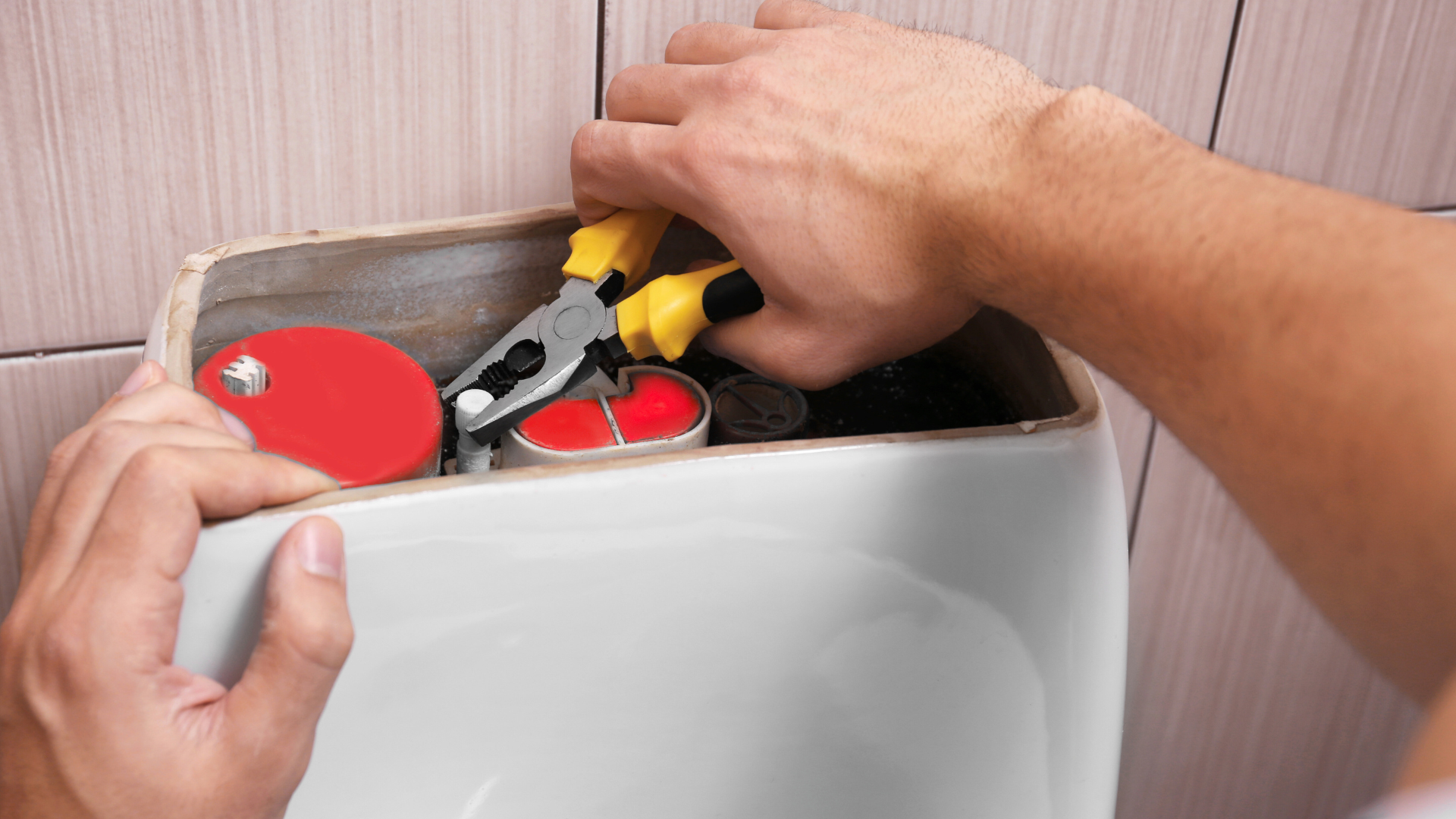 A person is fixing a toilet with pliers.