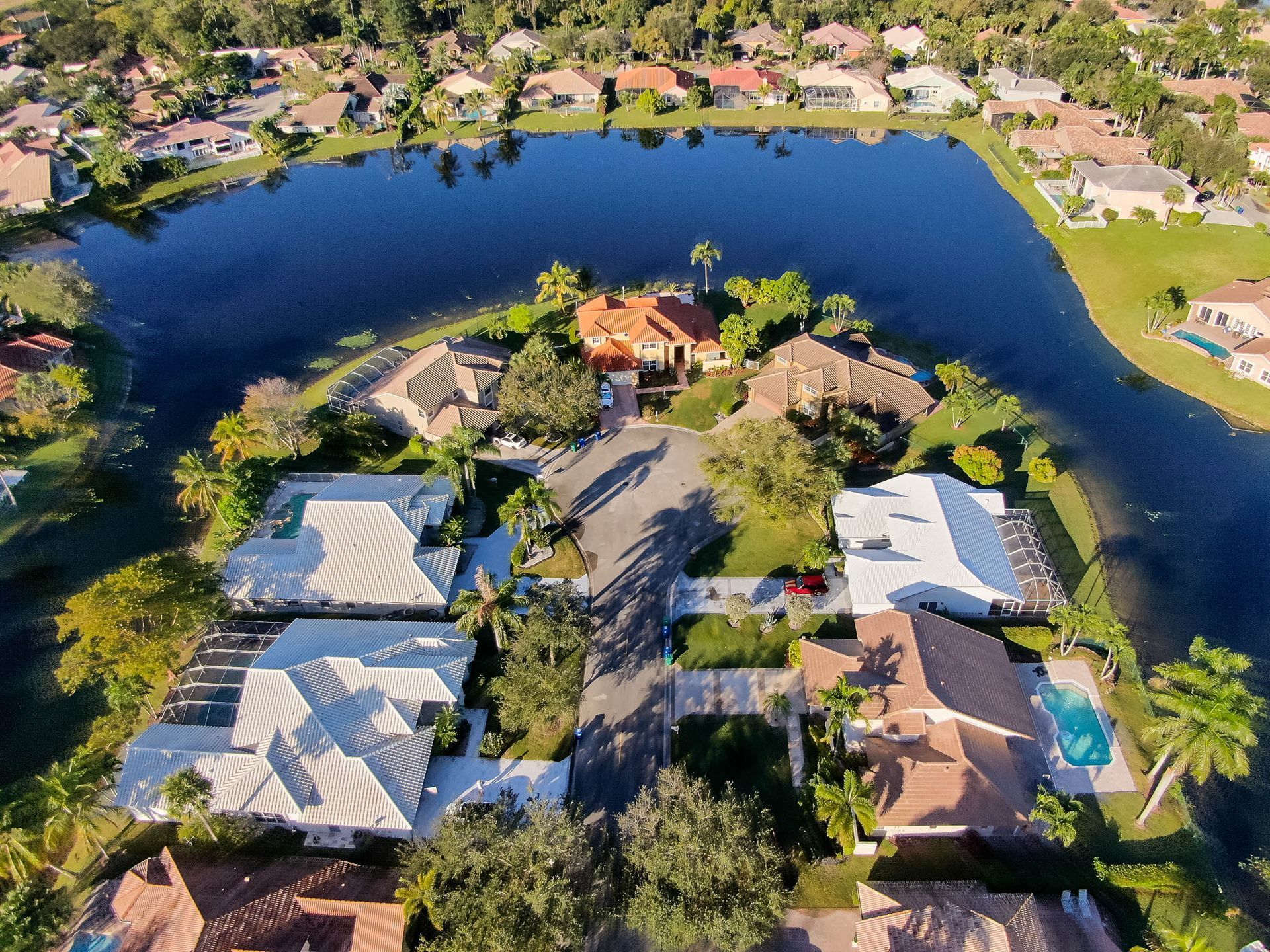 HVAC technician in blue uniform servicing outdoor air conditioning unit on a white building.