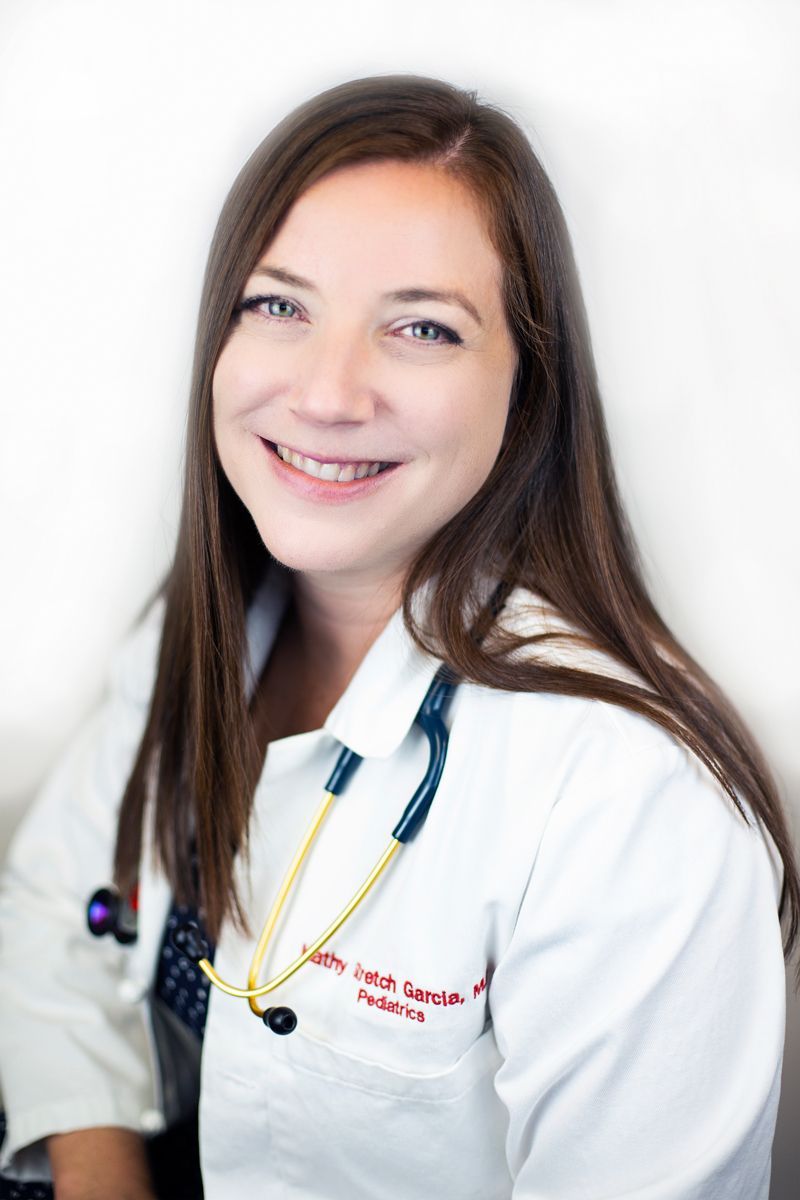 A woman in a white lab coat with a stethoscope around her neck