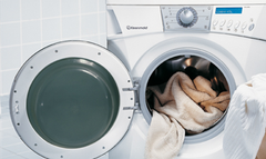 A washing machine with the door open and clothes in it