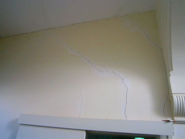 A semi truck is carrying a large excavator on a trailer.