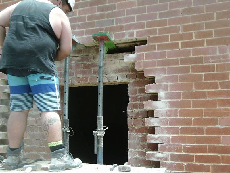 A semi truck is carrying a large excavator on a trailer.