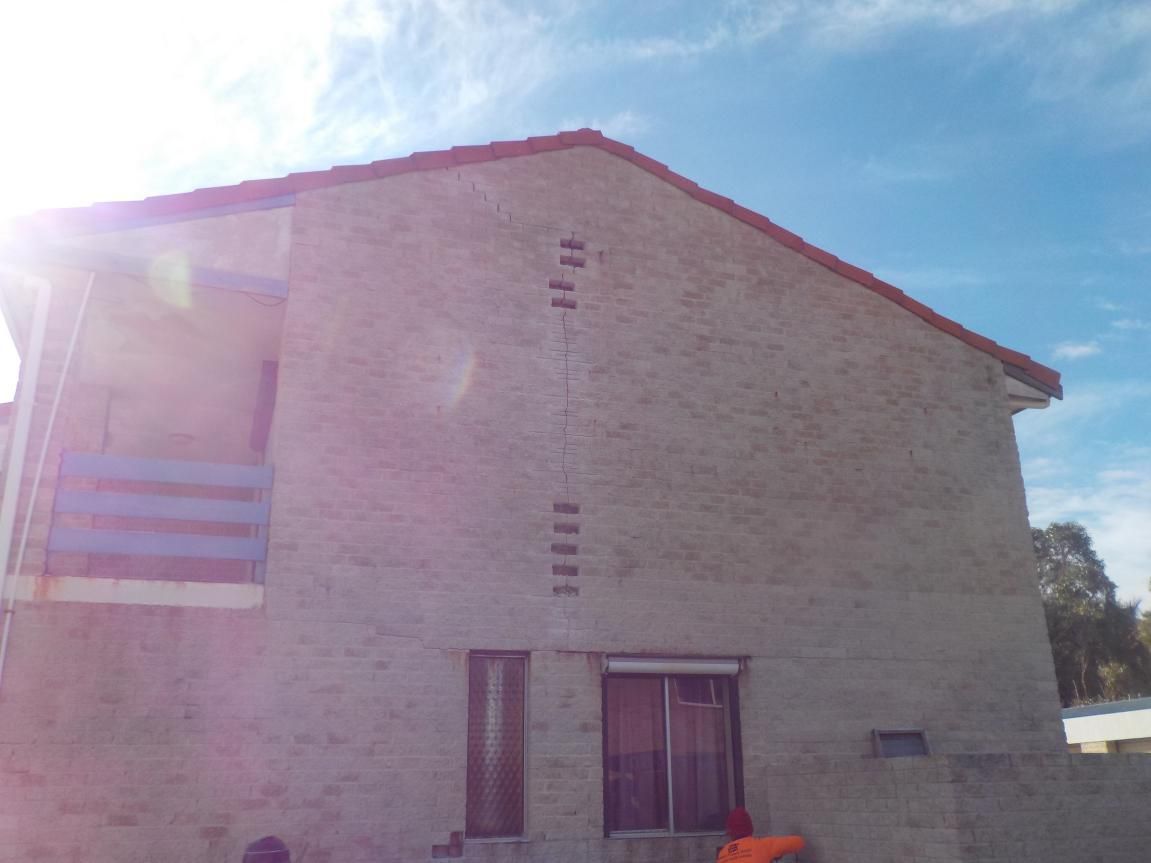 A semi truck is carrying a large excavator on a trailer.