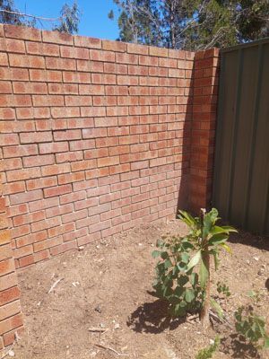 Brick retaining wall construction and retaining wall repair