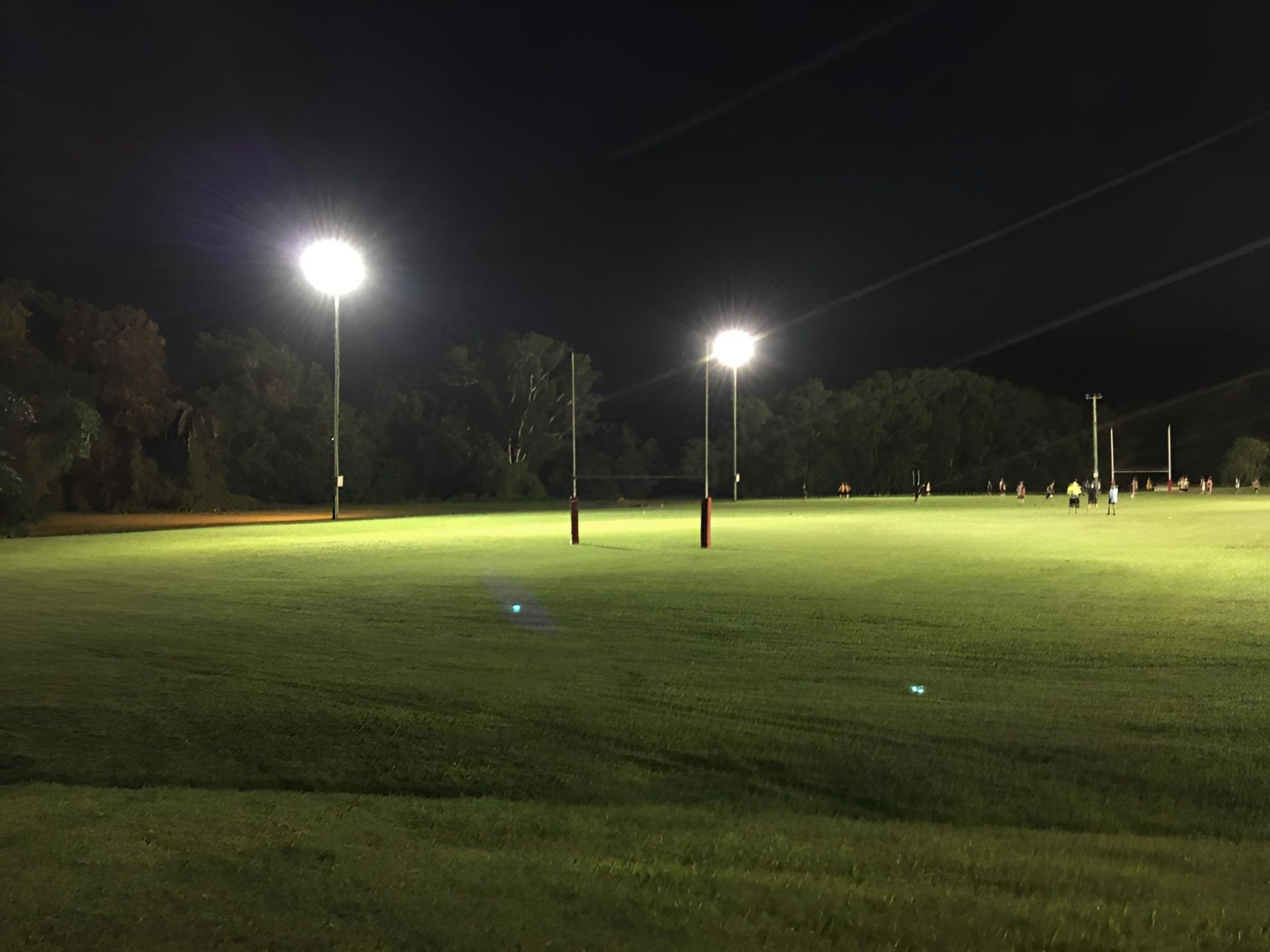 A Golf Course is Lit Up at Night With a Lot of Lights — Reilly Electrical Services in Yandina, QLD