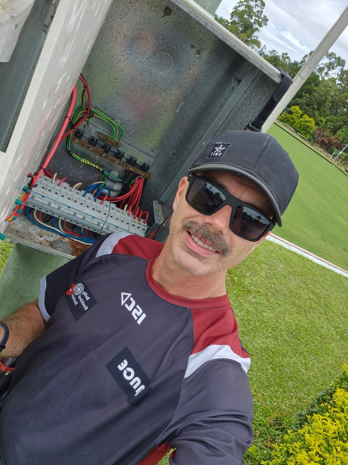 A Man Wearing Sunglasses in Front of an Electrical Box — Reilly Electrical Services in Yandina, QLD