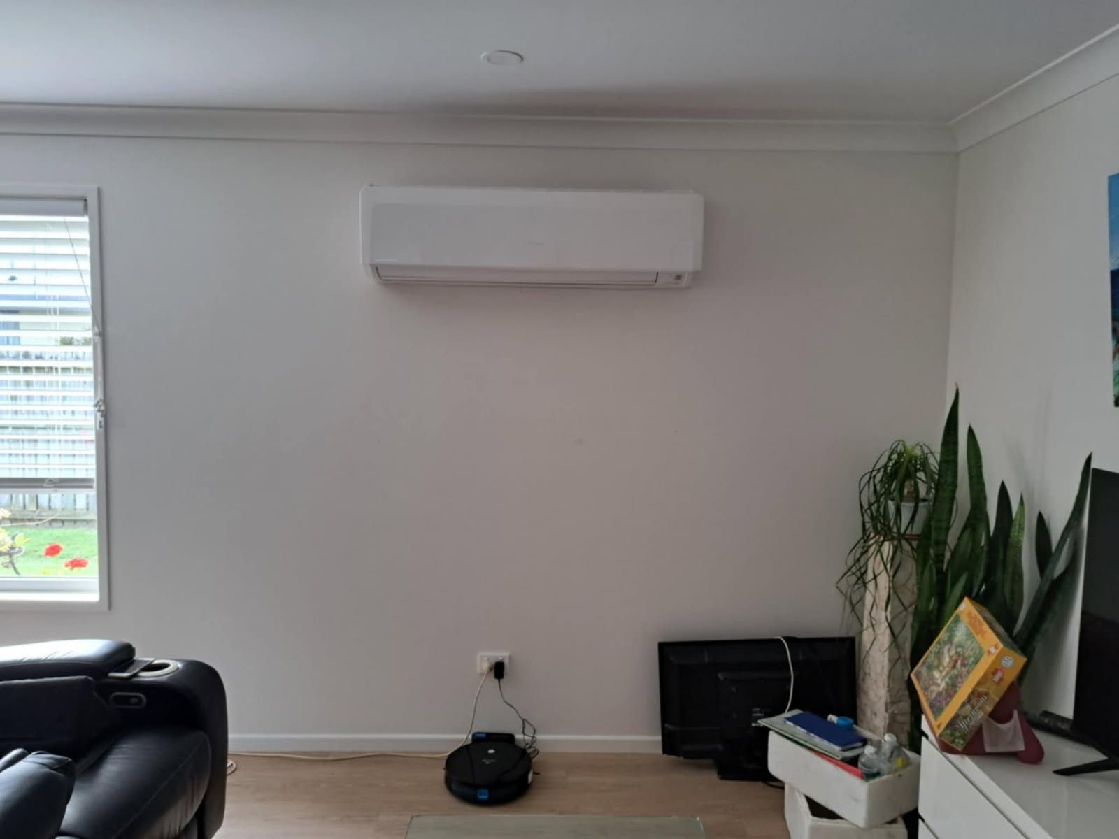 A Man is Standing on a Scaffolding Fixing a Light Fixture — Reilly Electrical Services in Yandina, QLD