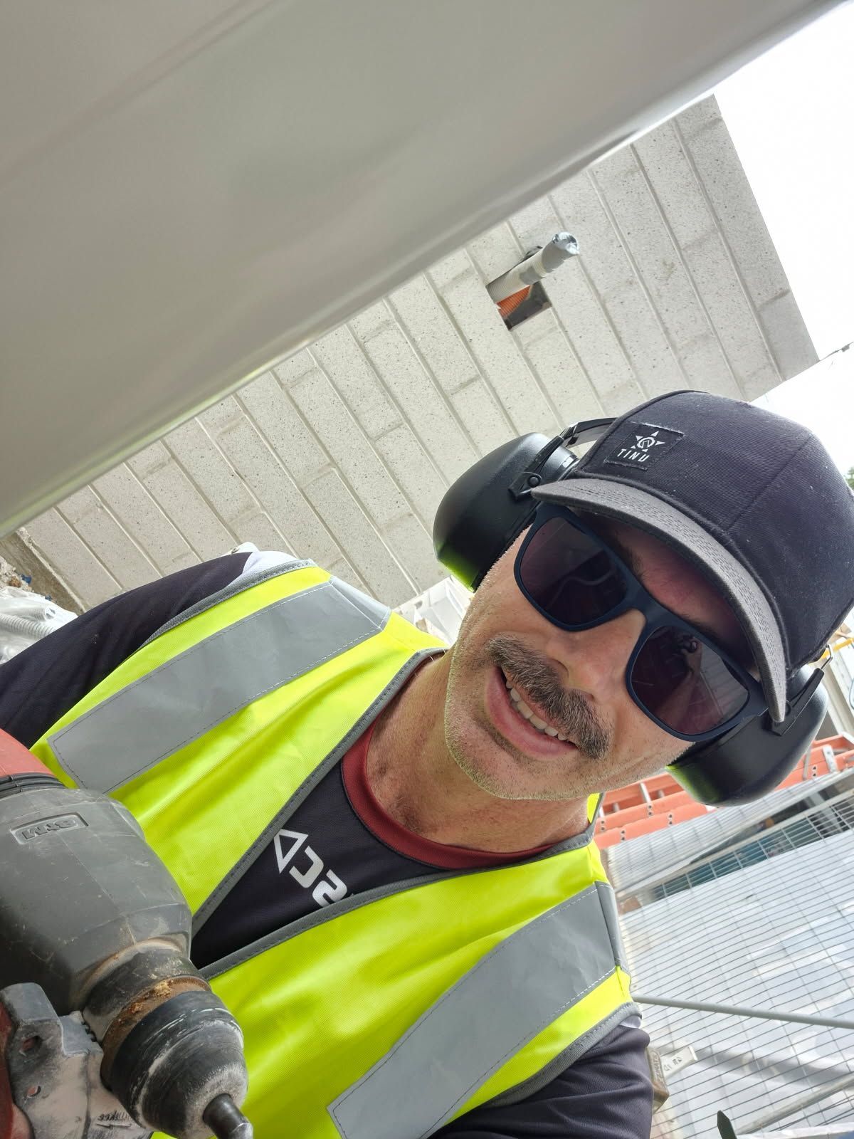 A Man is Working on a Water Pump Outside of a Building — Reilly Electrical Services in Yandina, QLD