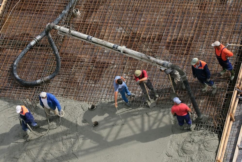 A Group of Construction Workers Are Working on a Concrete Floor — Felto's Concrete Line Pumping in Corindi Beach, NSW