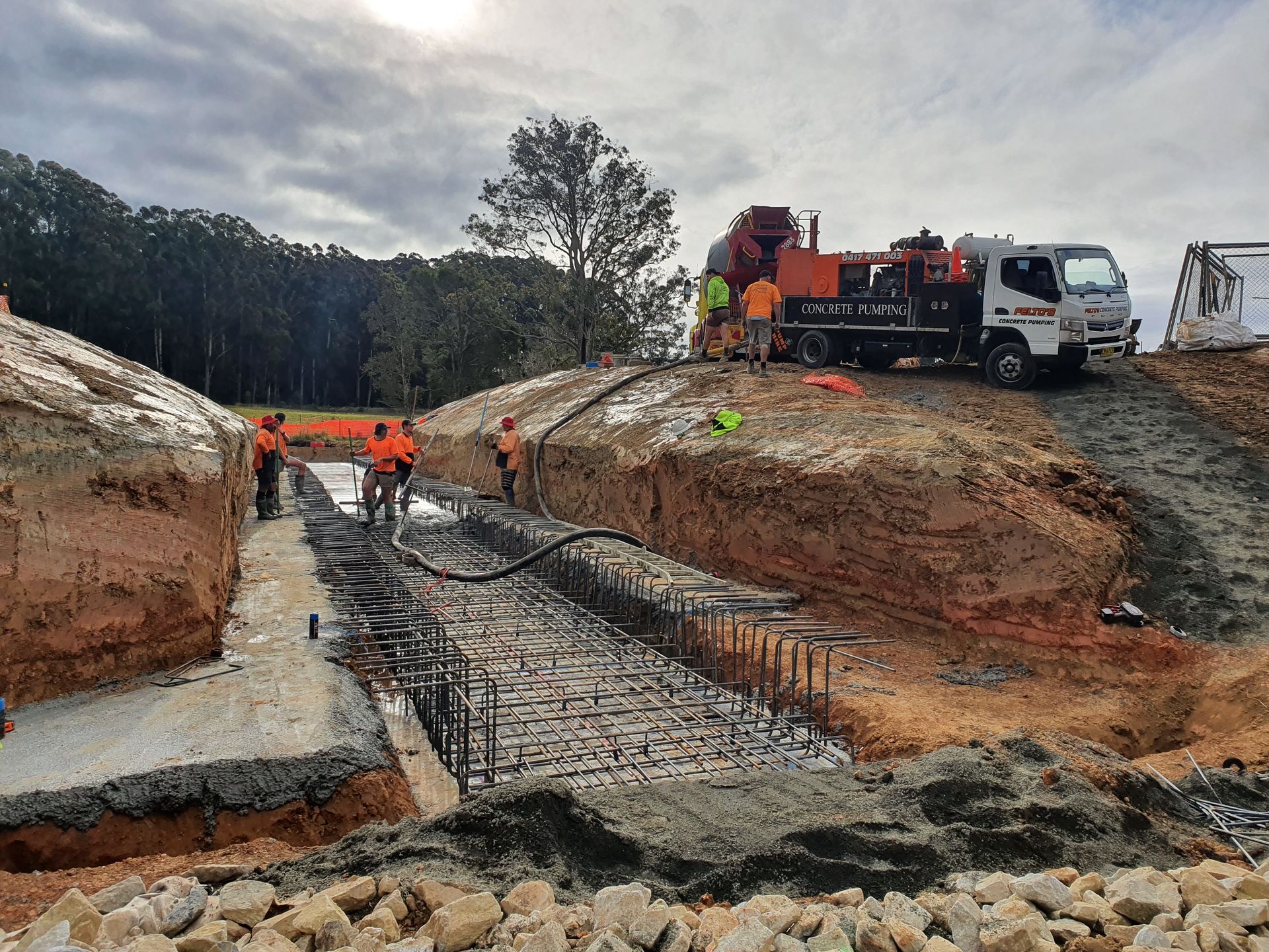 Concrete crew working on foundations with a Felto’s line pump truck on site — Felto's Concrete Line Pumping in Coffs Harbour, NSW