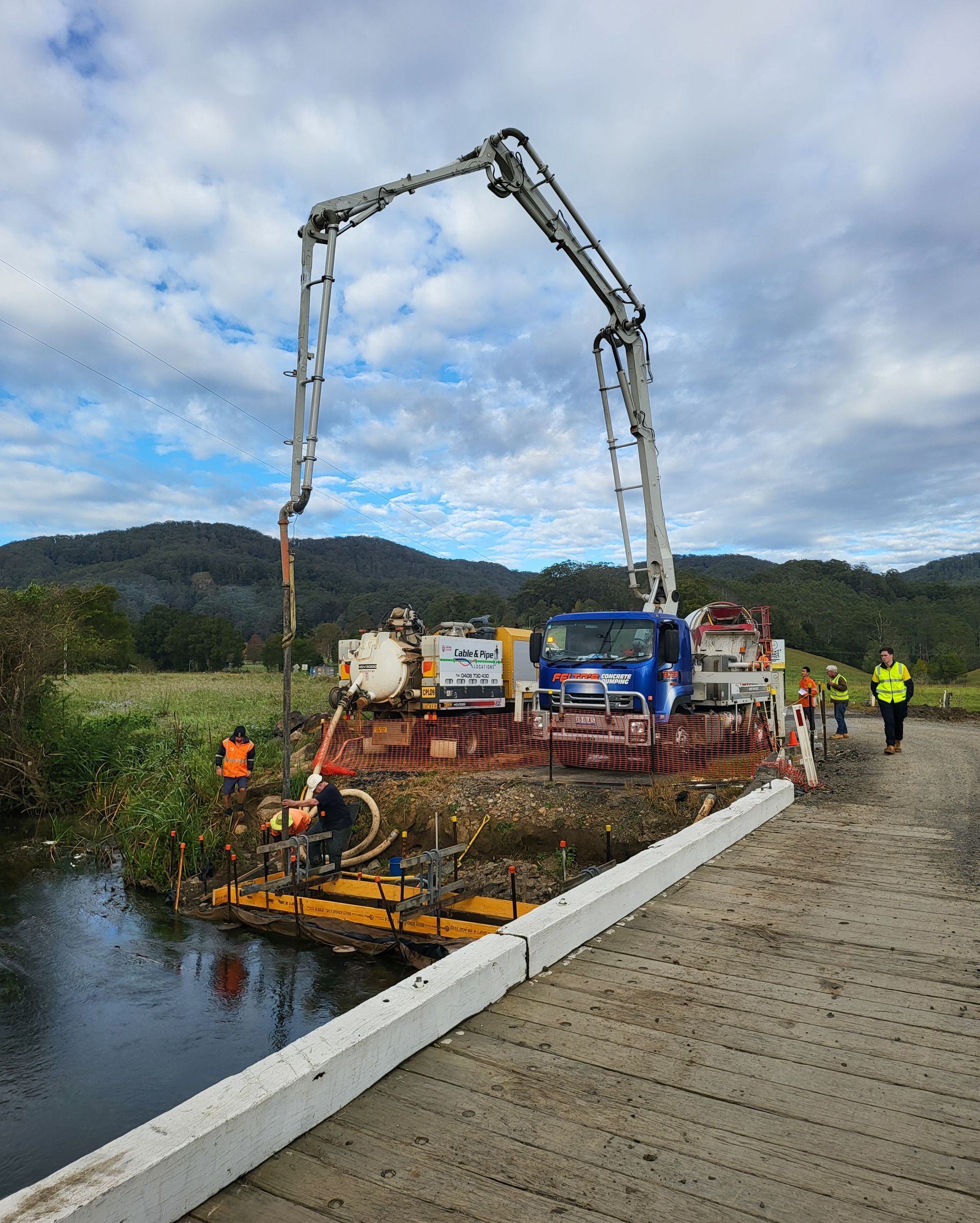 Felto’s boom pump pouring concrete near a bridge over water_ Felto's Concrete Line Pumping in Coffs Harbour, NSW