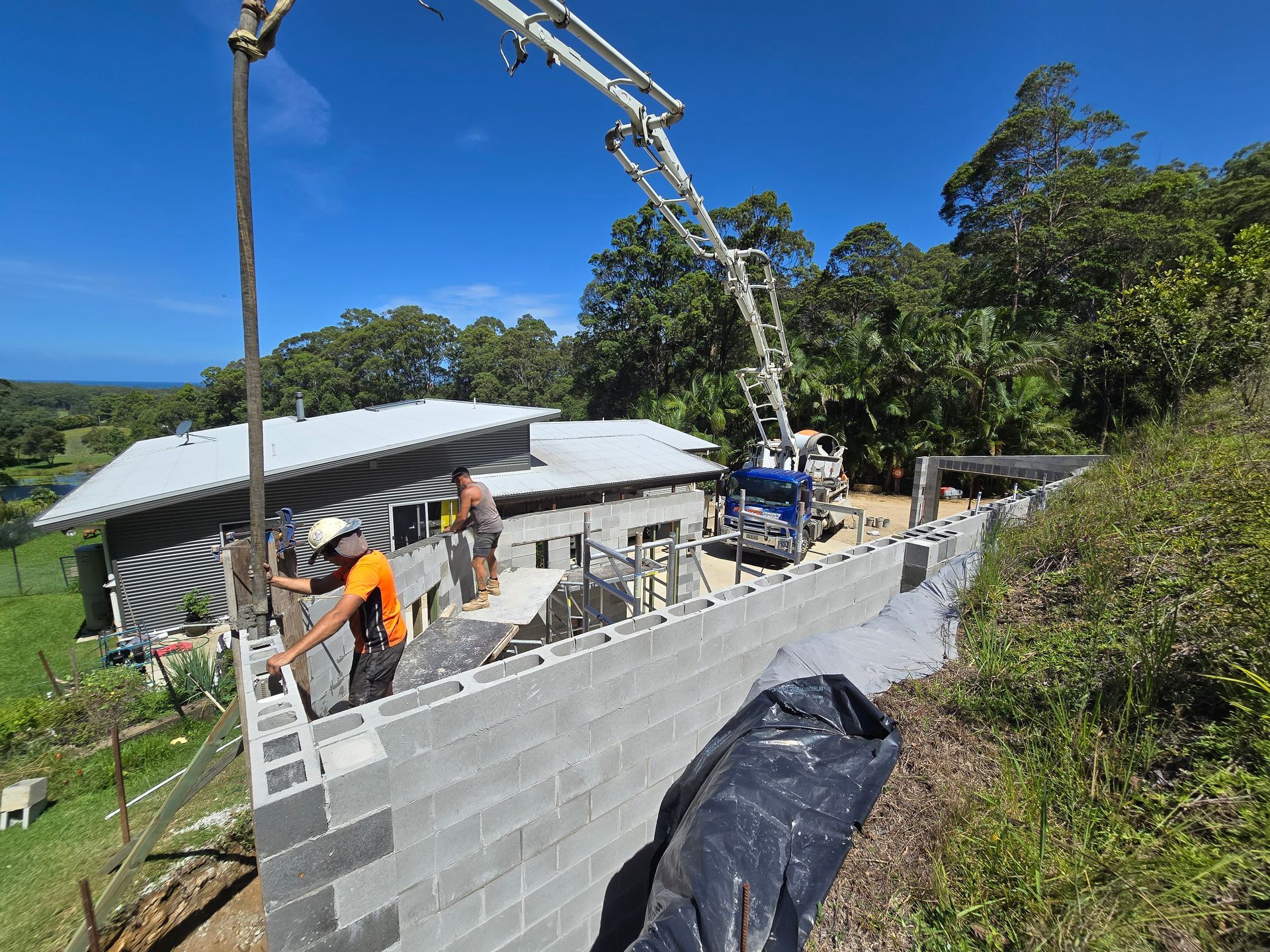 Felto’s boom pump pouring concrete for a block wall construction — Felto's Concrete Line Pumping in Coffs Harbour, NSW.