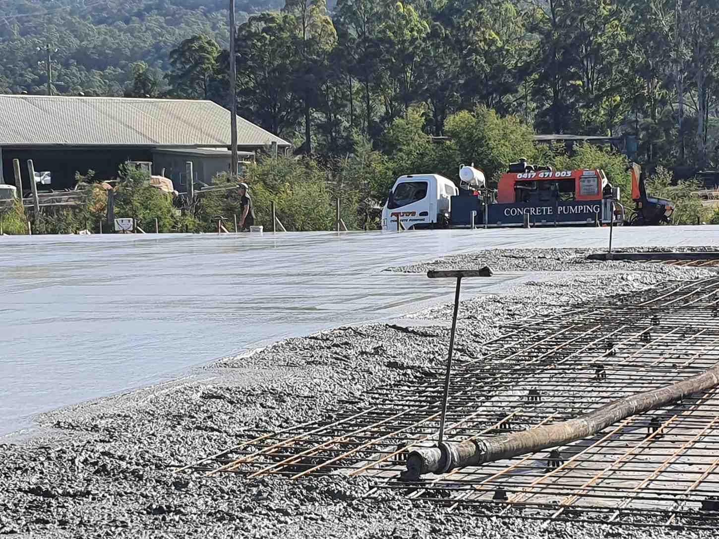 A Truck is Driving Down a Road Next to a Body of Water — Felto's Concrete Line Pumping in Bellingen, NSW