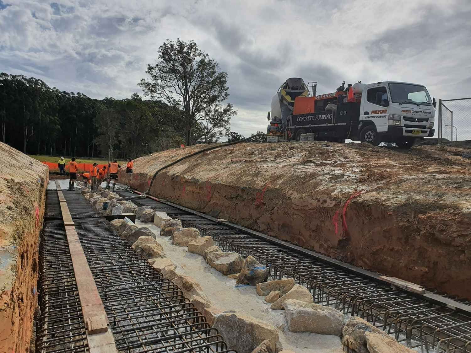 A Group of Construction Workers Are Working on a Construction Site — Felto's Concrete Line Pumping in Coffs Harbour, NSW
