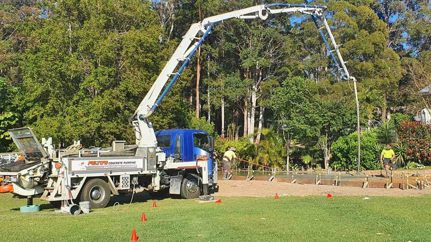 A Concrete Pump Truck is Pumping Concrete Into a Field — Felto's Concrete Line Pumping in Woolgoolga, NSW