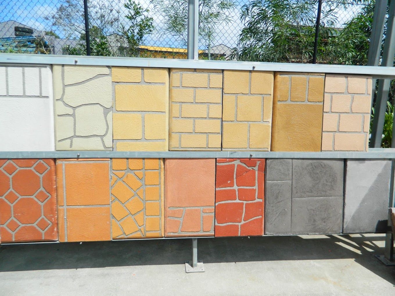 A display board featuring an array of square concrete tiles in various colors, textures, and patterns.
