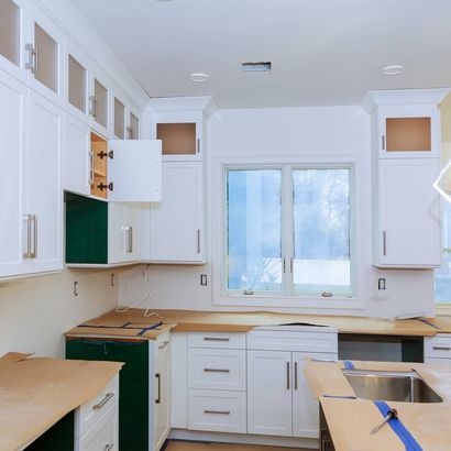 A kitchen with white cabinets and a window — Windemere, FL — Valor Homes Construction LLC