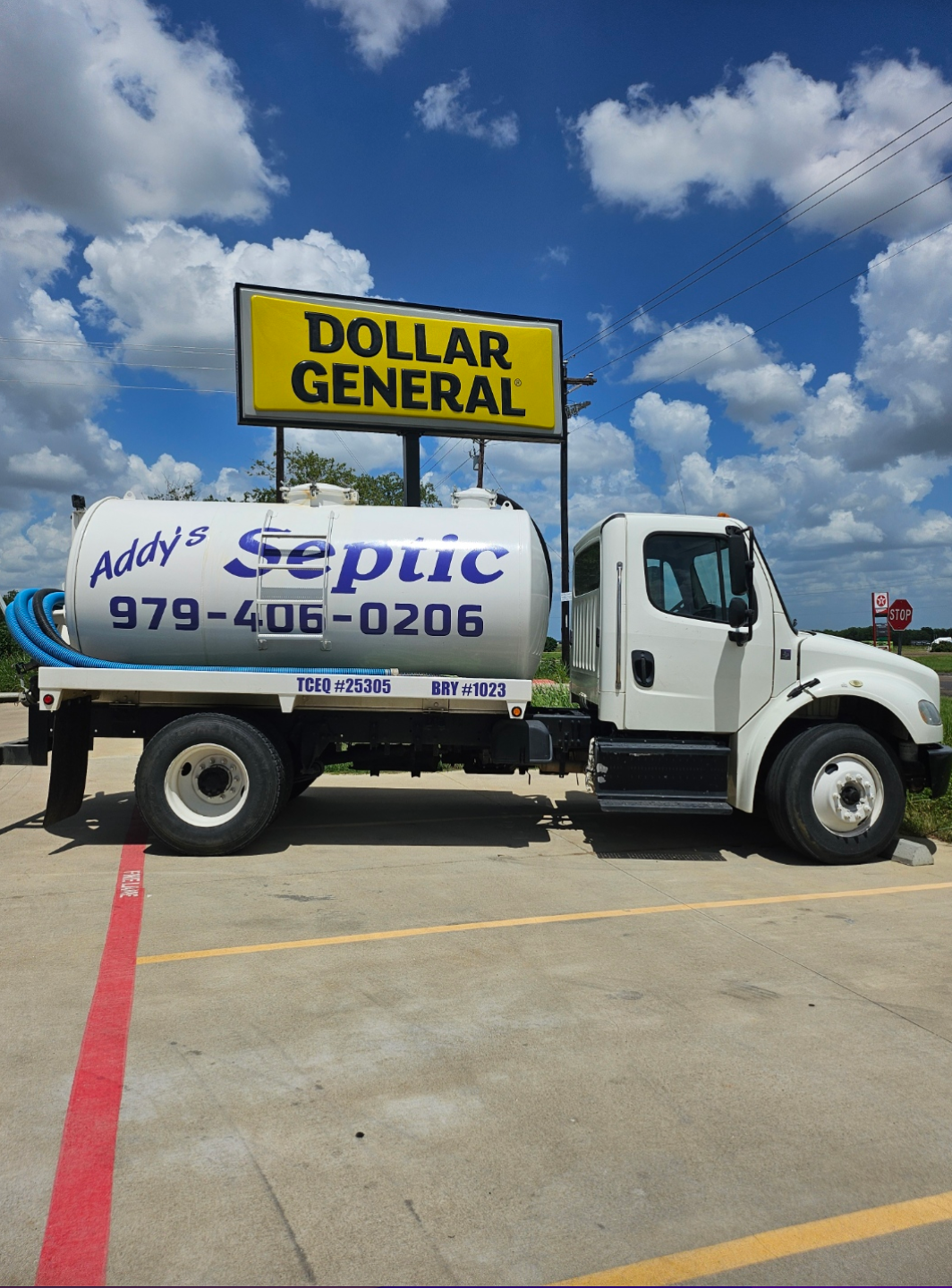 A white truck is parked in a parking lot next to a building.