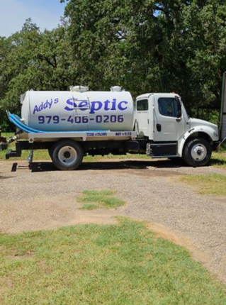A white truck is parked in a parking lot next to a building.
