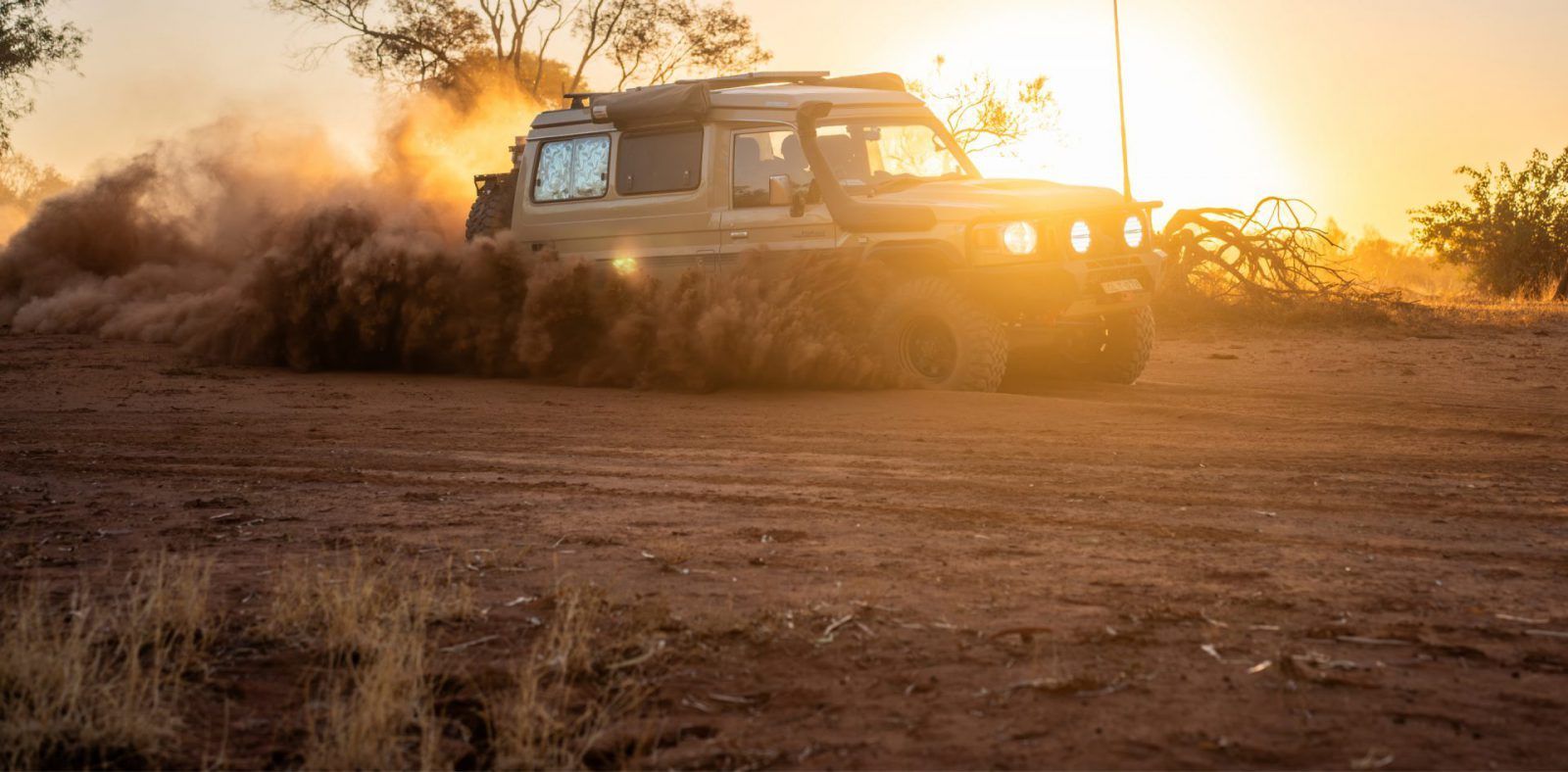 A Tan SUV Kicks Up Dust as It Drives Through a Dry — Cairns Tyre Specialists In Cairns City, QLD