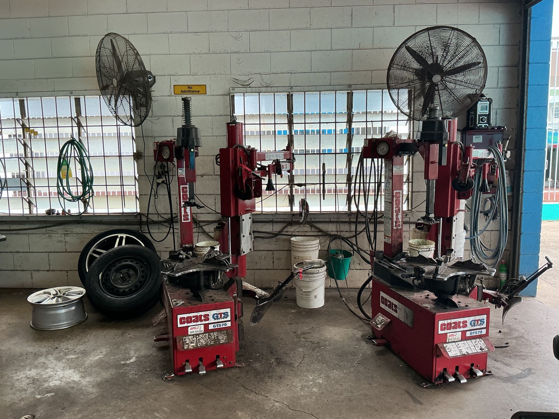 Two Red Tire Changing Machines in a Garage — Cairns Tyre Specialists In Cairns City, QLD