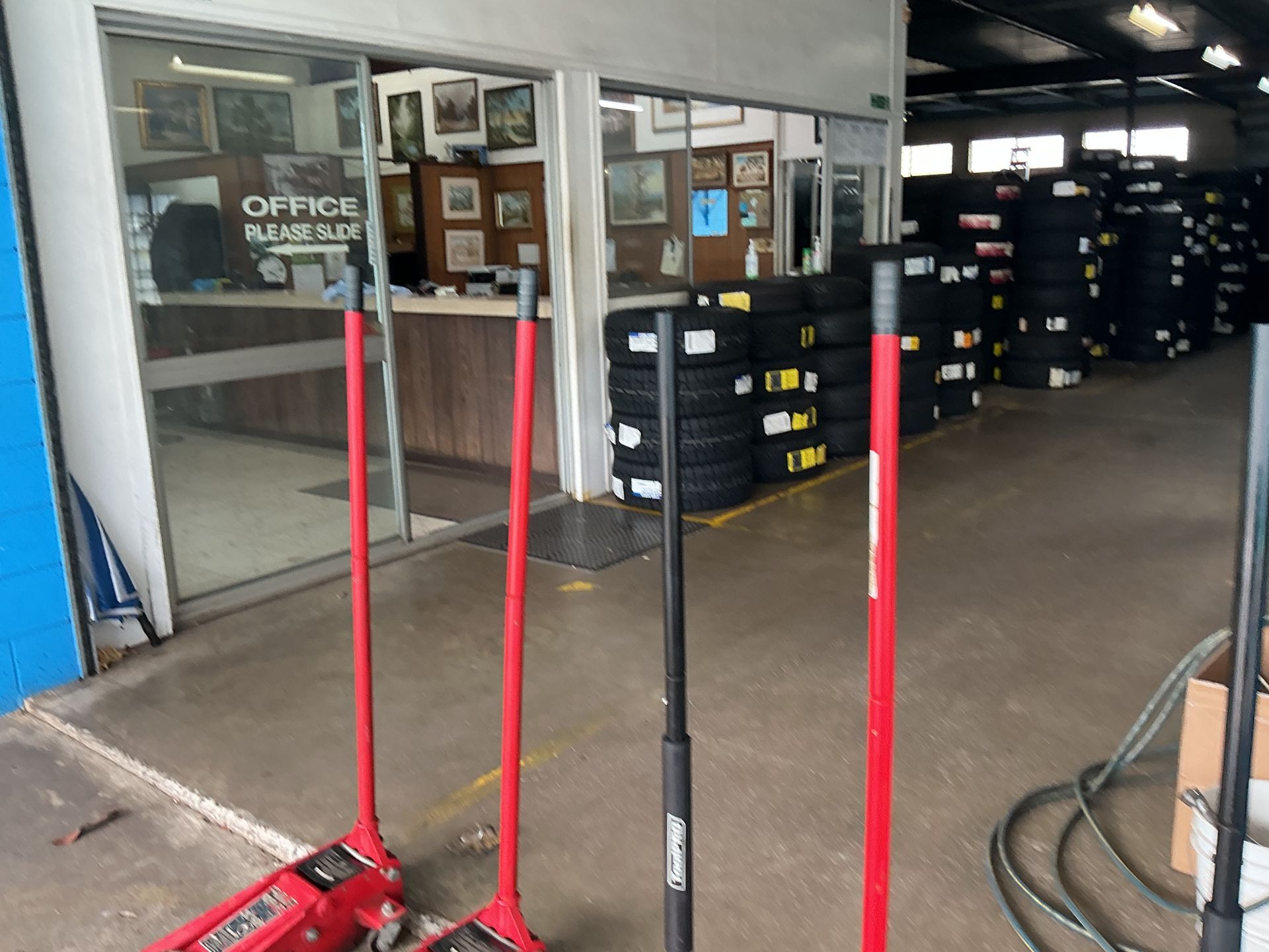 Entrance to a Tire Shop With Floor Jacks and Stacks of Tires — Cairns Tyre Specialists In Cairns City, QLD