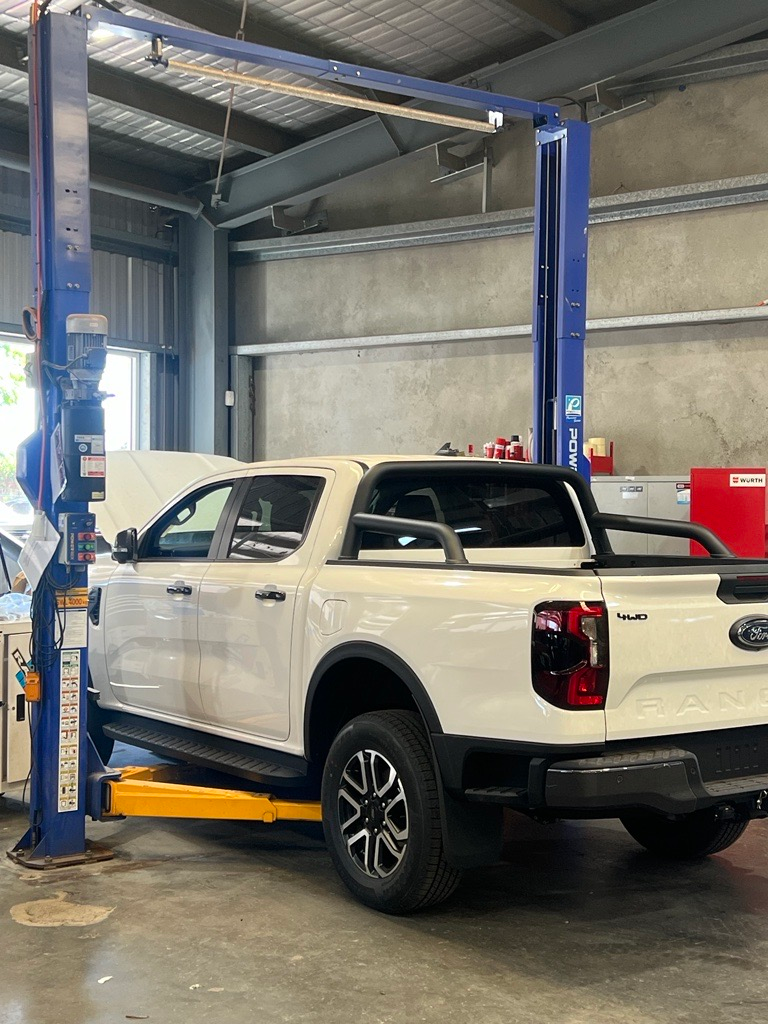 Two Cars Red And White Coloured, White Car Lift by Hoist — Hoist Repair Near Dubbo