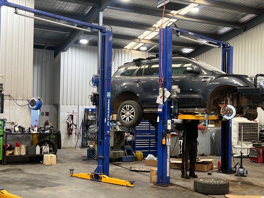 Two Cars at Repair Station One Lifted Above And One On The Ground — Hoist in Mudgee