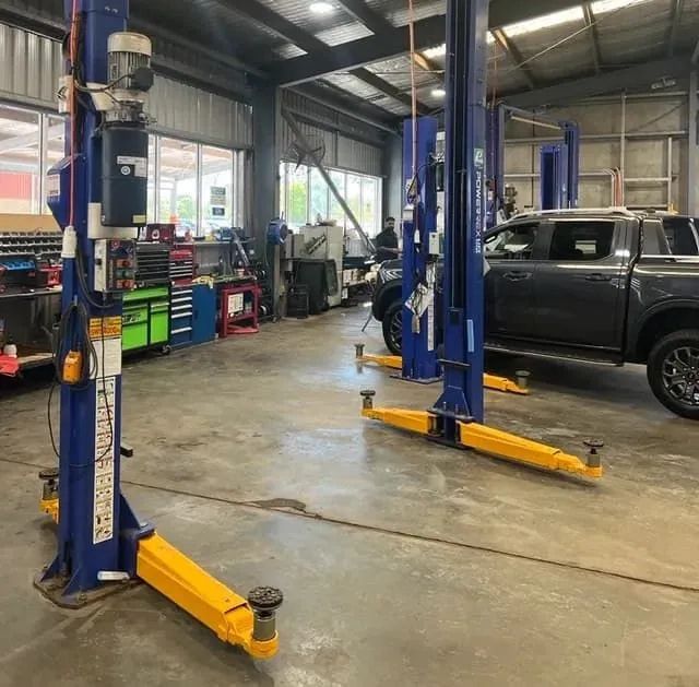Two Cars at Repair Station One Lifted Above And One On The Ground — Vehicle Hoist Near Dubbo