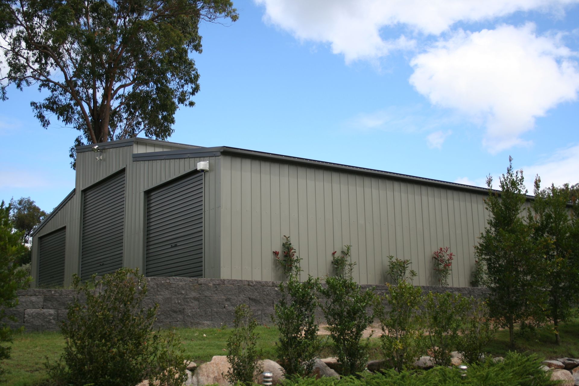 Large Metal Shed With Gray Siding and Roller Doors — Fair Dinkum Builds Mid North Coast  in Bobs Farm, NSW