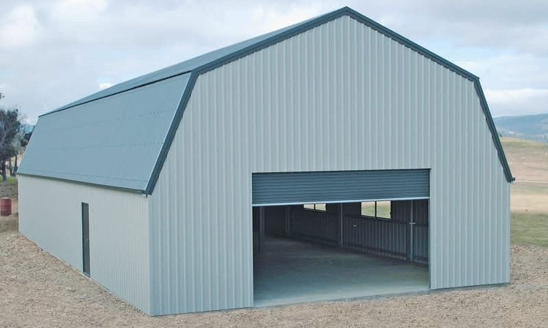 Steel barn with a gray exterior and a large opening.