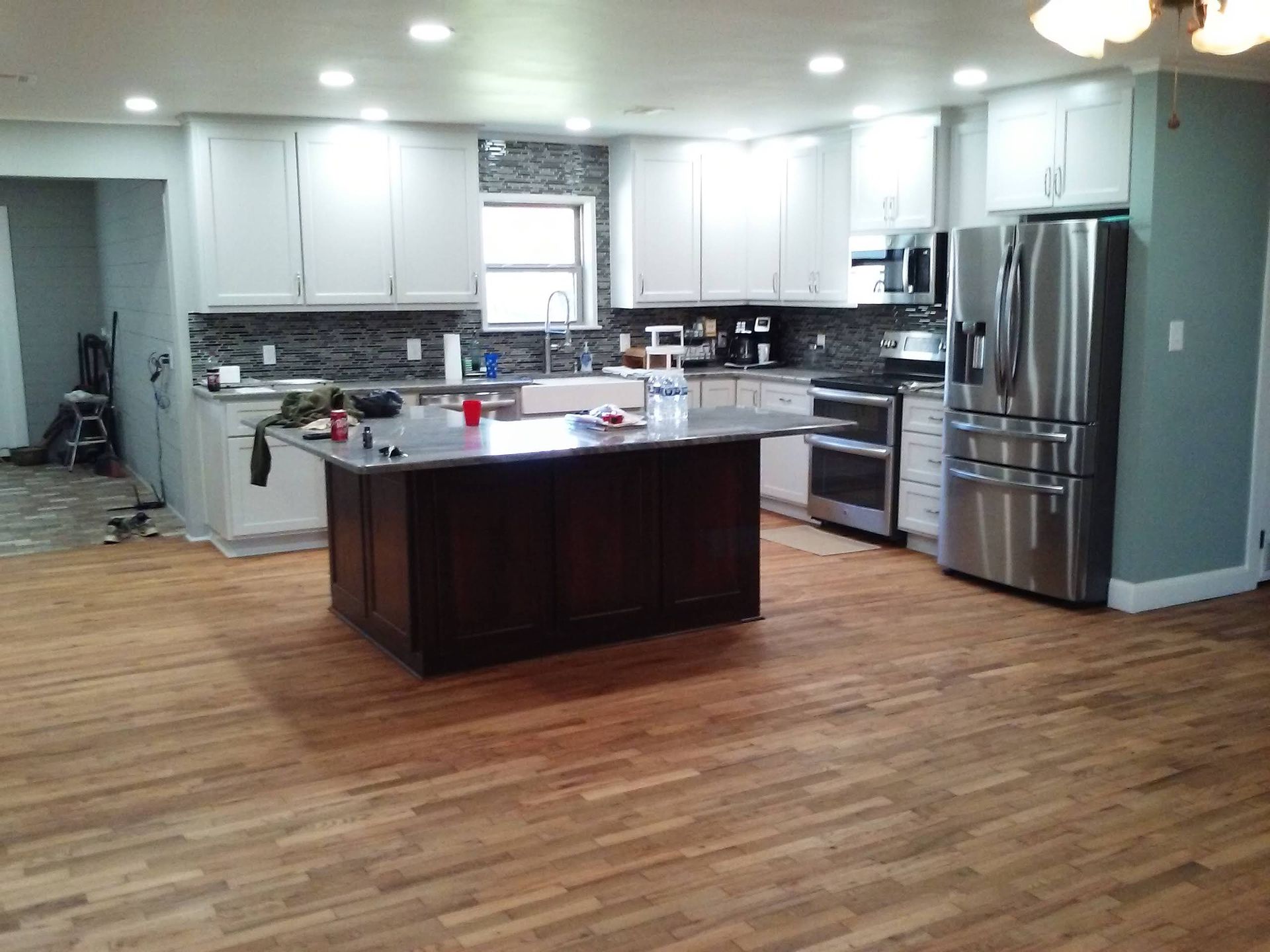 A kitchen with stainless steel appliances and a large island in the middle.