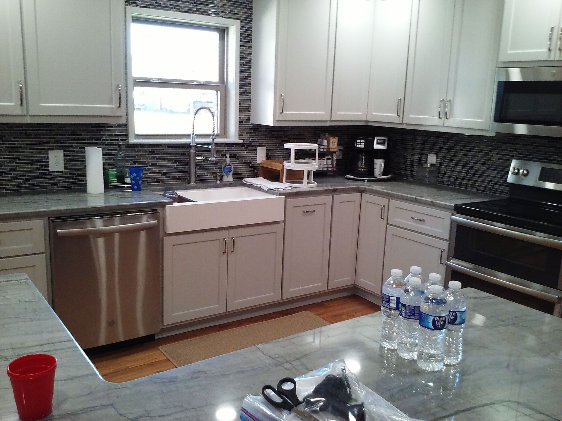 A kitchen with white cabinets and stainless steel appliances