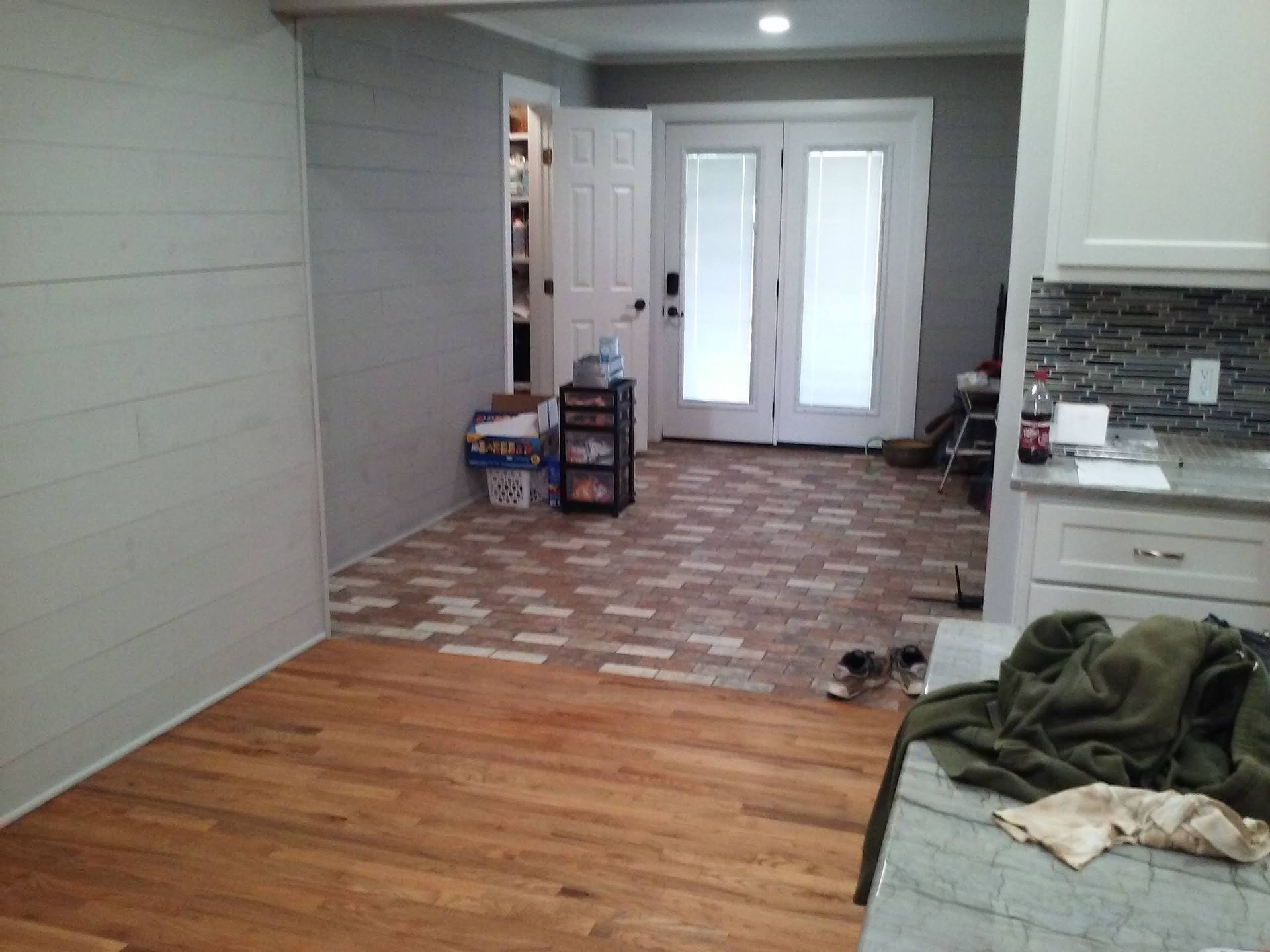 A kitchen with a wooden floor and a dog on the counter.