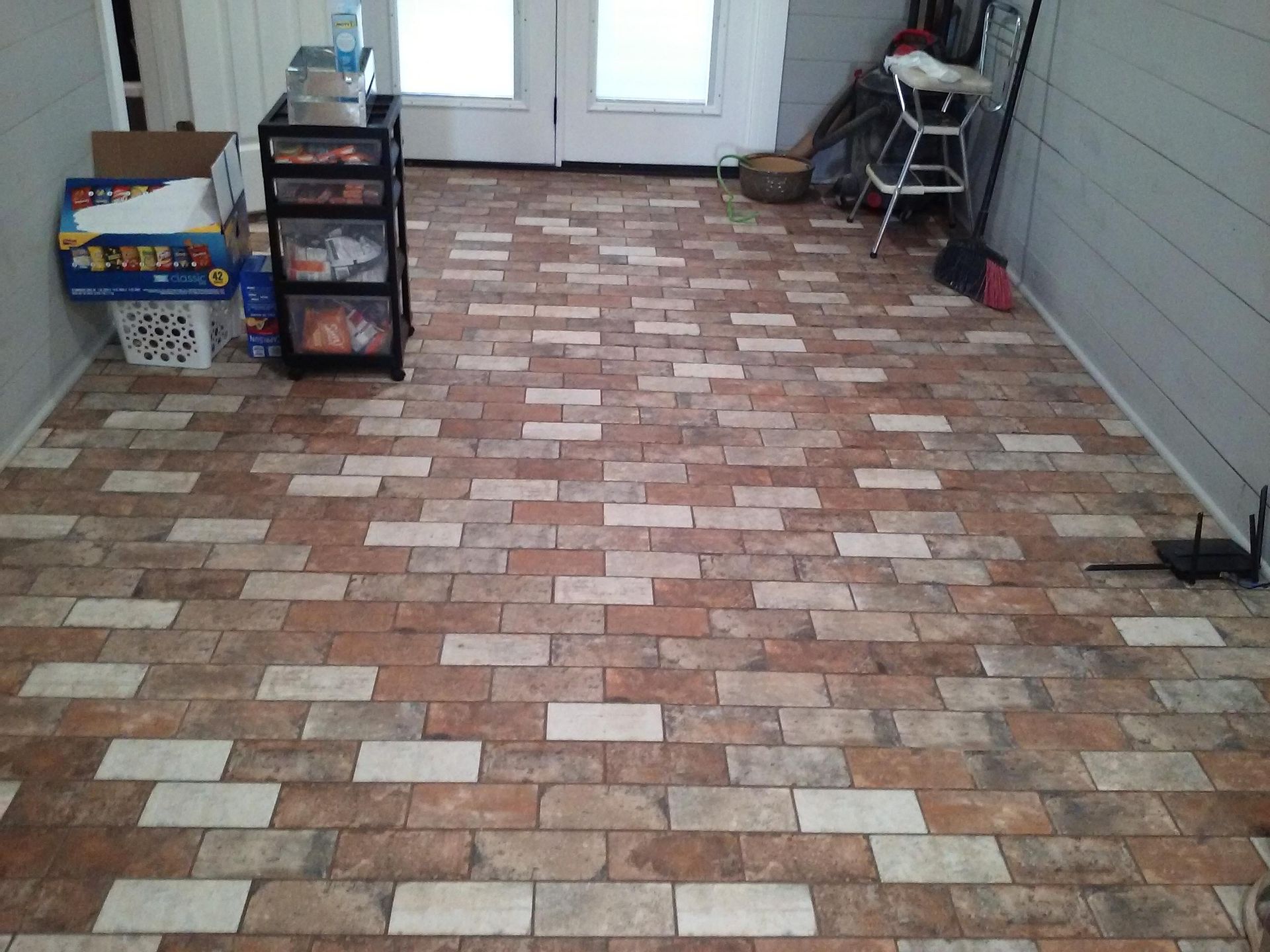 A room with a brick floor and a box that says ' silver ' on it
