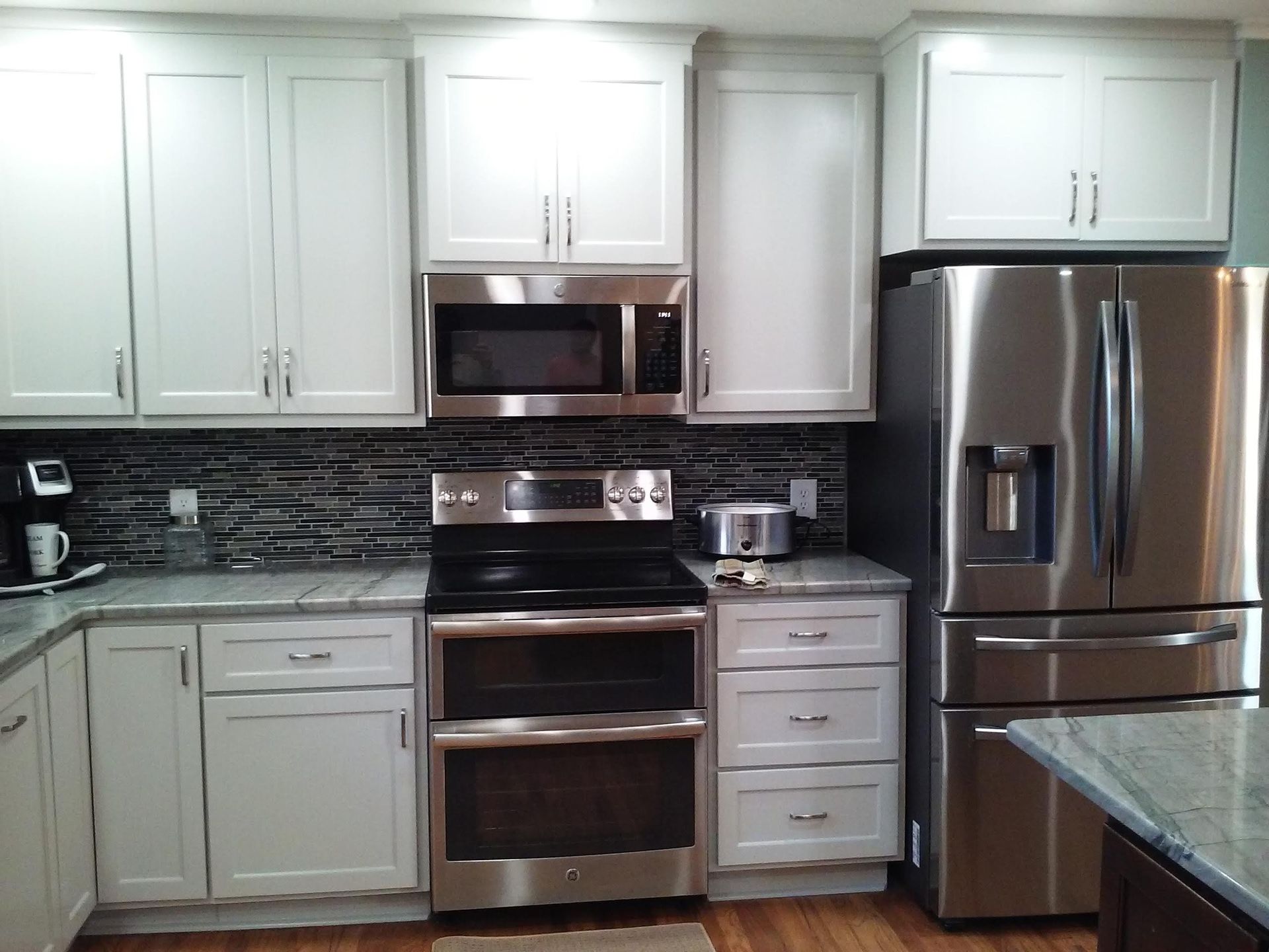 A kitchen with stainless steel appliances and white cabinets