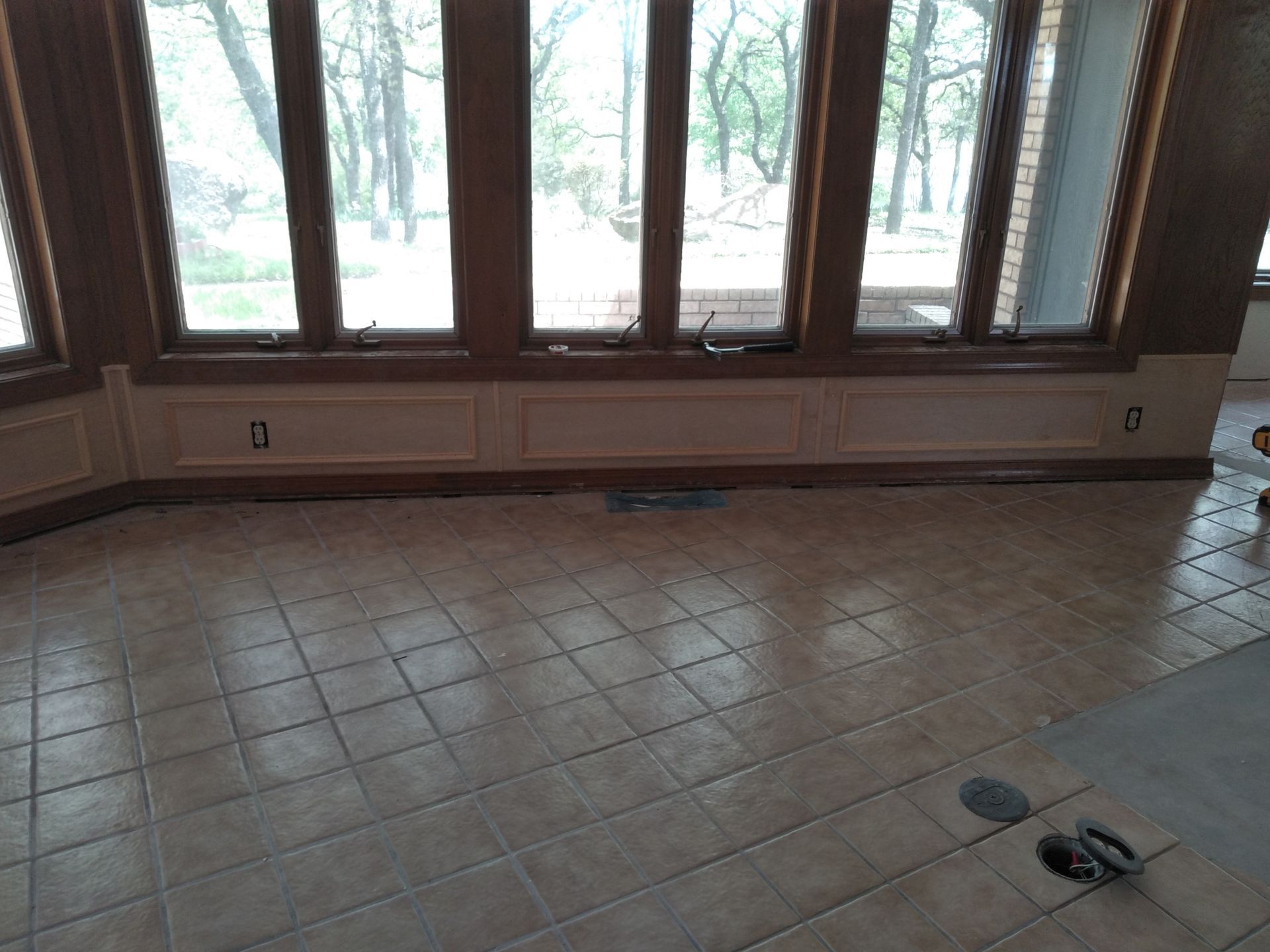 A room with a tiled floor and a lot of windows.