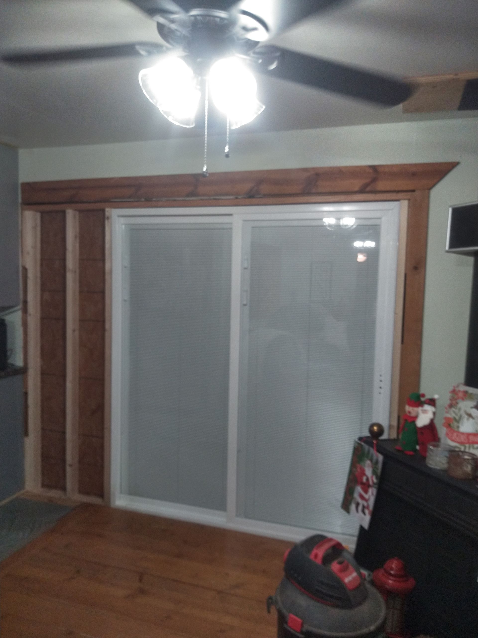 A living room with a sliding glass door and a ceiling fan.