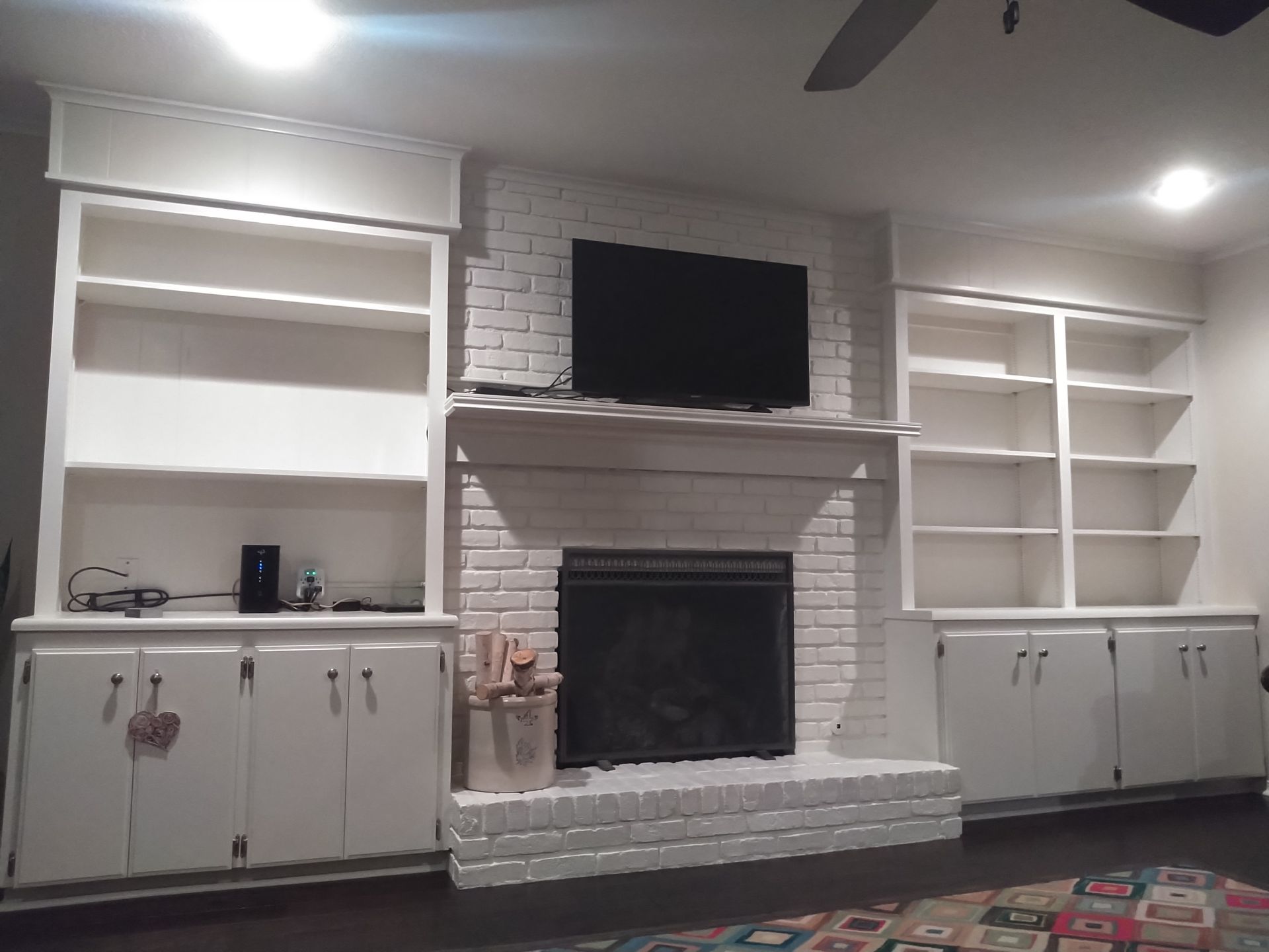 A living room with a fireplace and a flat screen tv