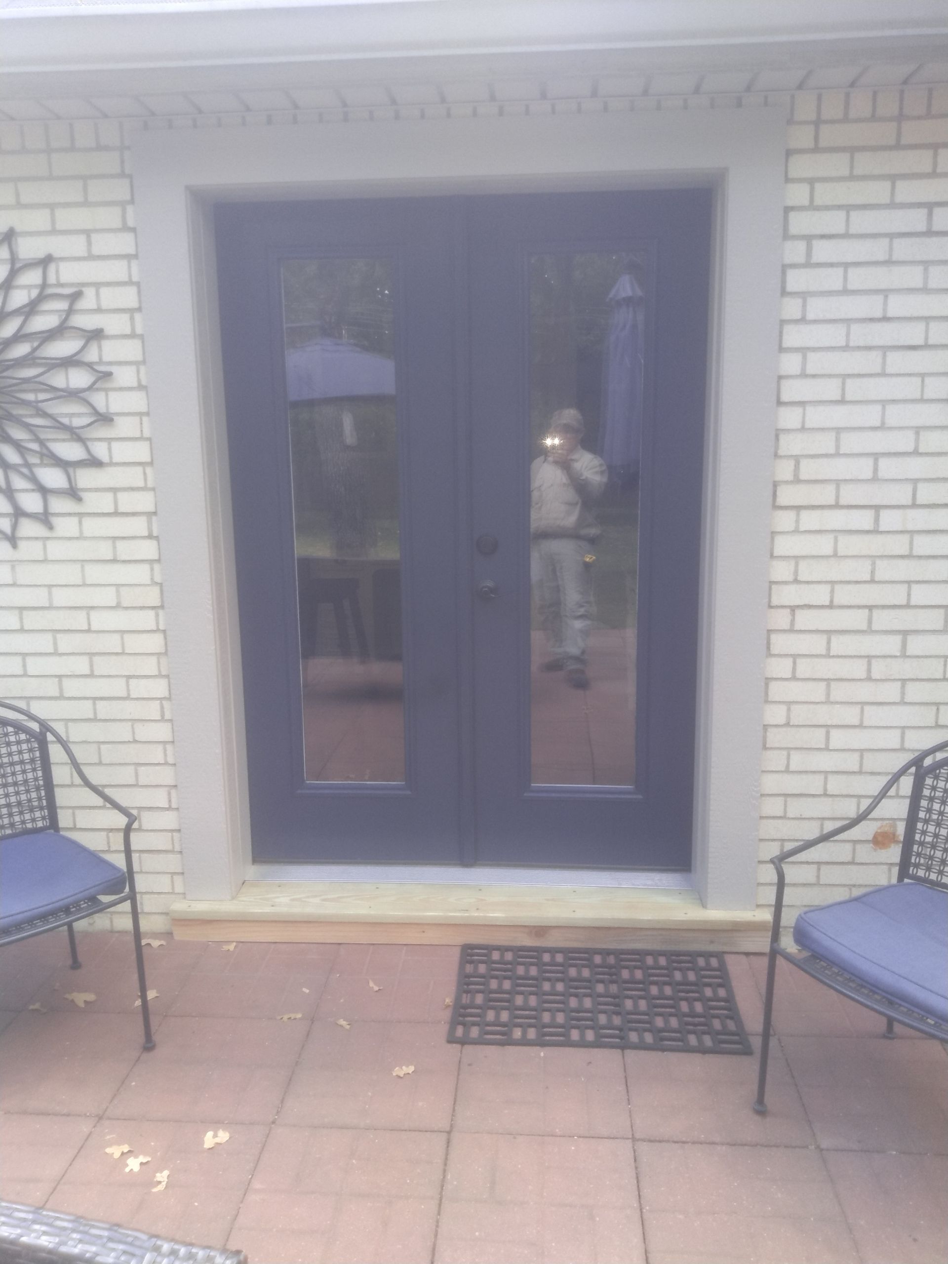 A couple of chairs are sitting on a patio in front of a door.