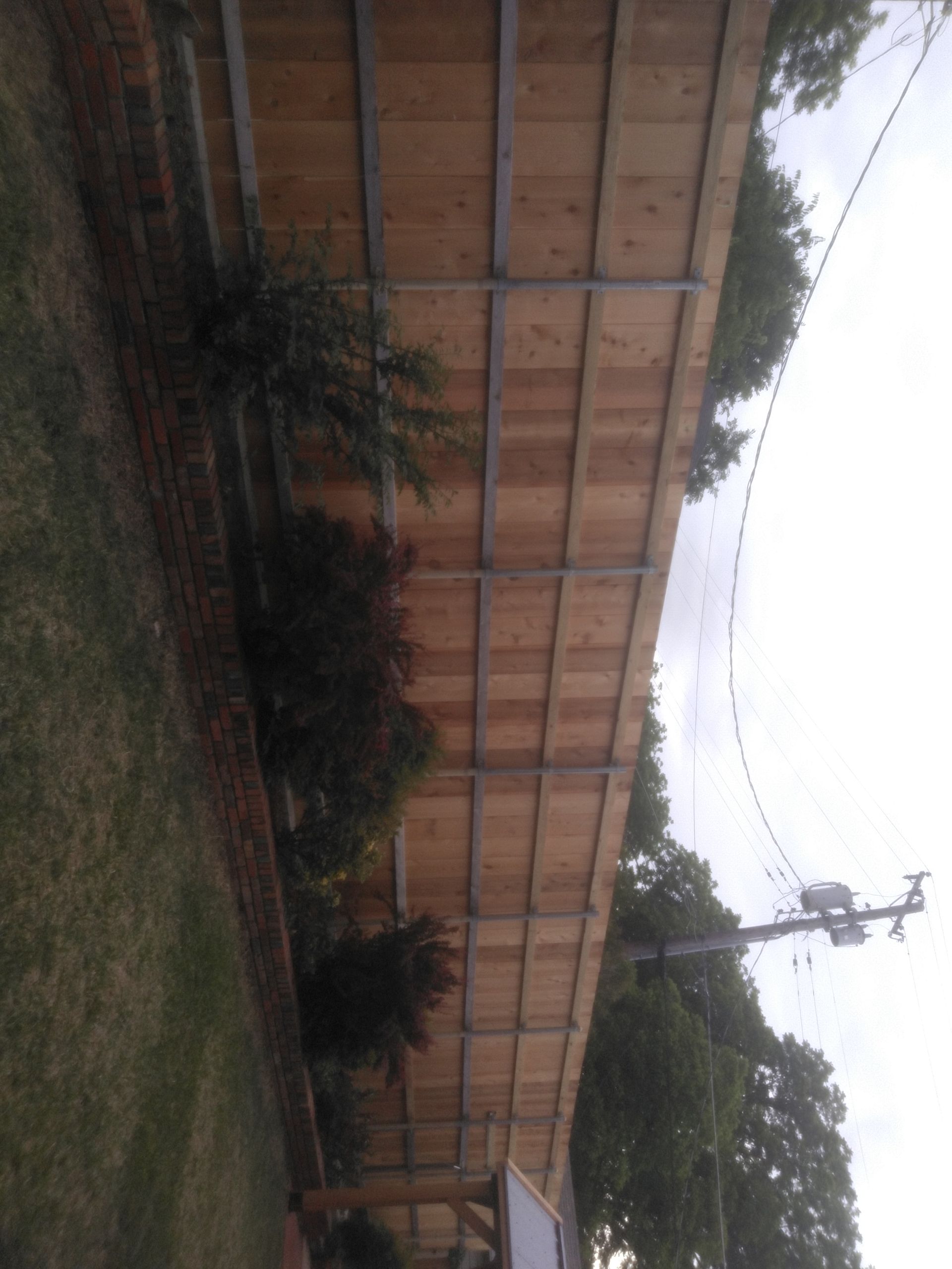 A wooden fence surrounds a lush green yard
